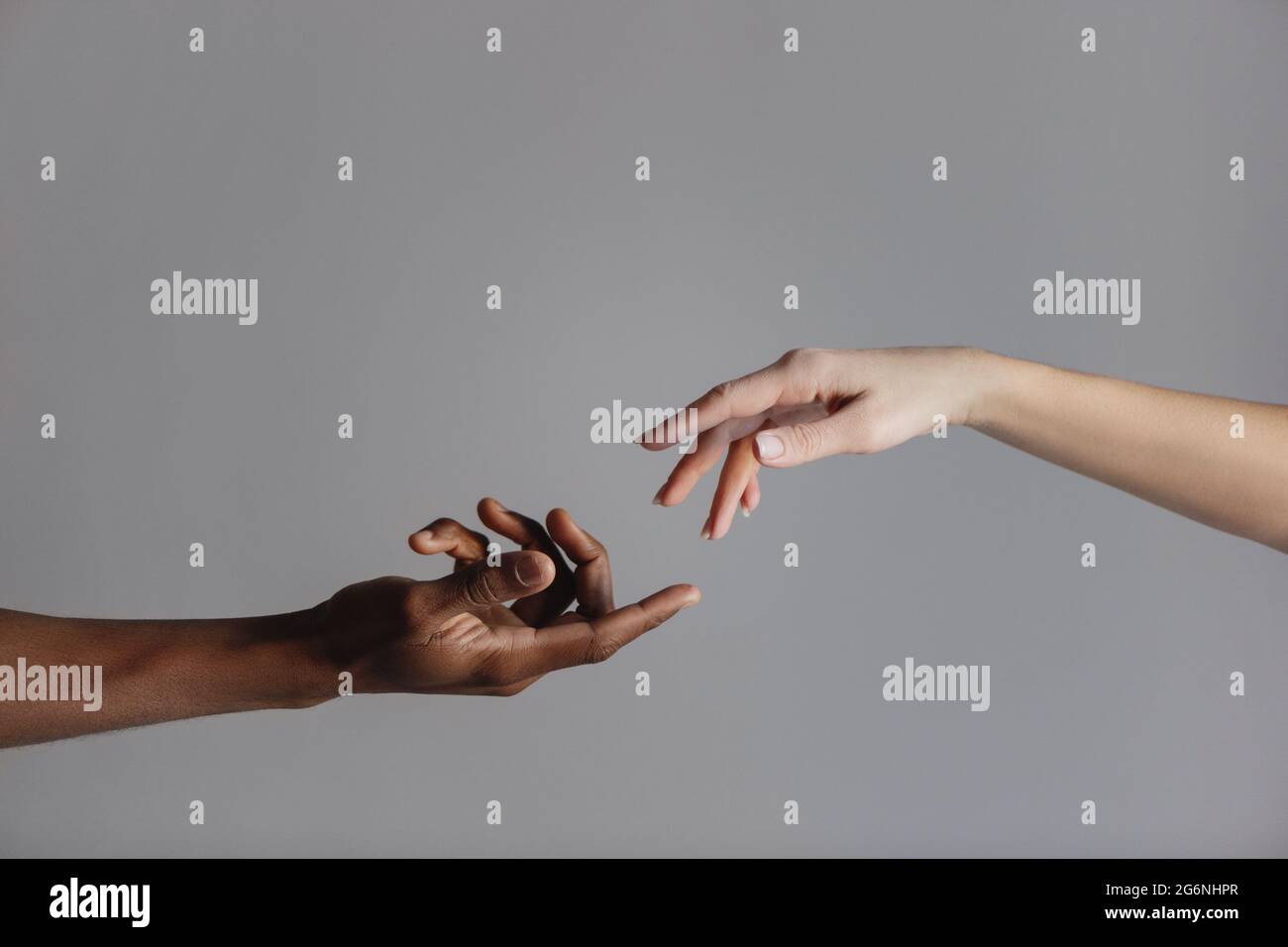 Les mains des hommes et des femmes se touchant les unes aux autres isolées sur fond gris. Banque D'Images