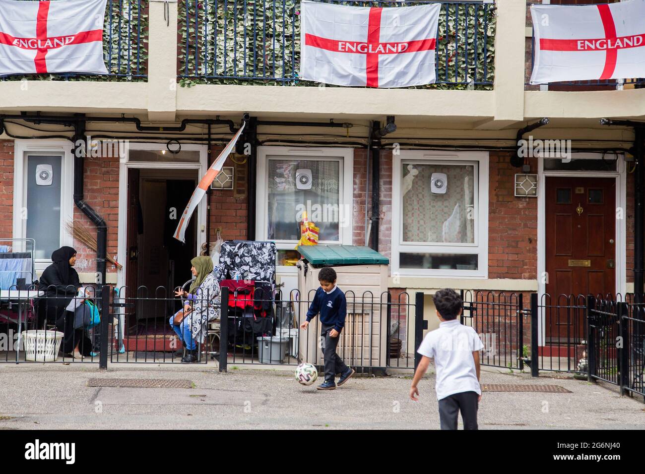 Londres, Royaume-Uni. 7 juillet 2021. Les enfants jouent au domaine Kirby à Bermondsey, au sud-est de Londres. Un domaine immobilier a été couvert de drapeaux anglais avant le match de la demi-finale contre le Danemark. Credit: Thabo Jaiyesimi/SOPA Images/ZUMA Wire/Alay Live News Banque D'Images
