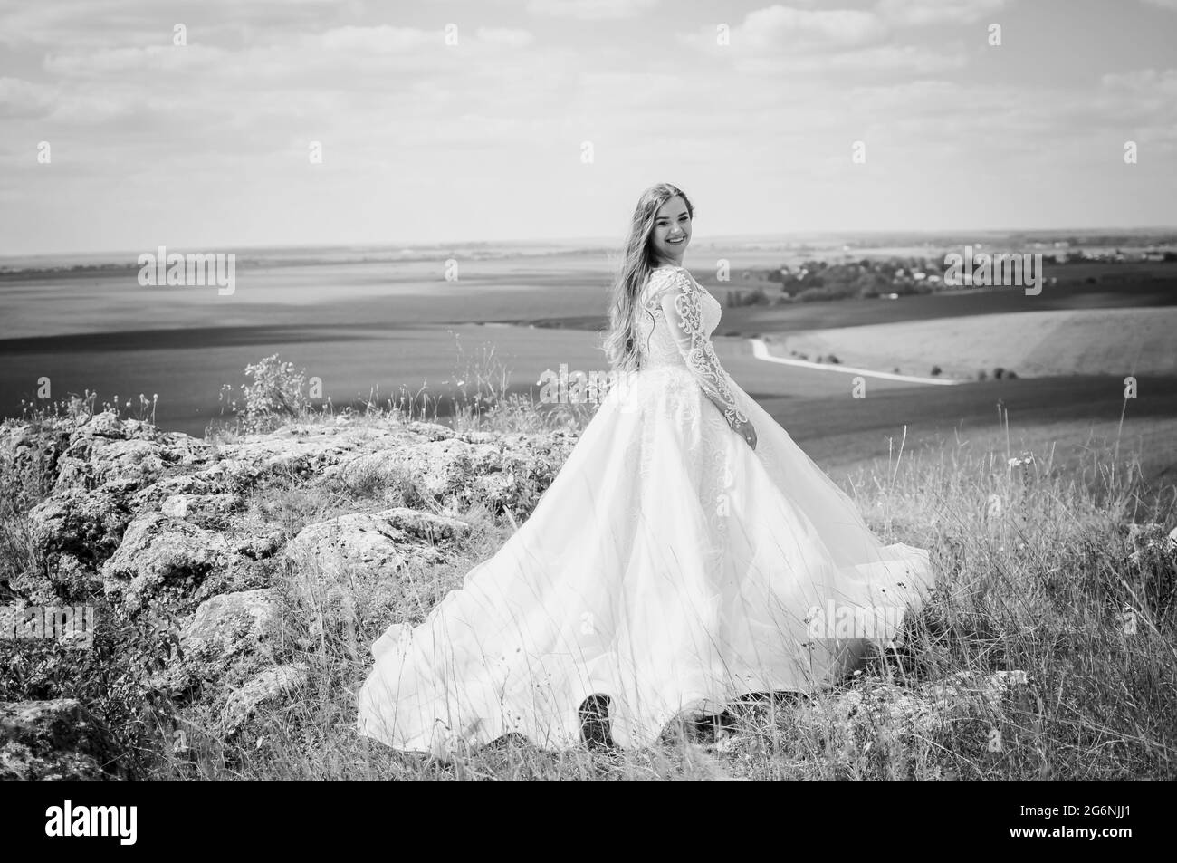 Une fille dans une robe de mariage blanche se tient sur la toile de