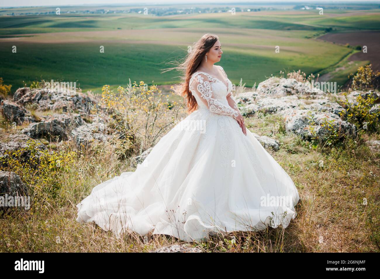 Une fille dans une robe de mariage blanche se tient sur la toile de