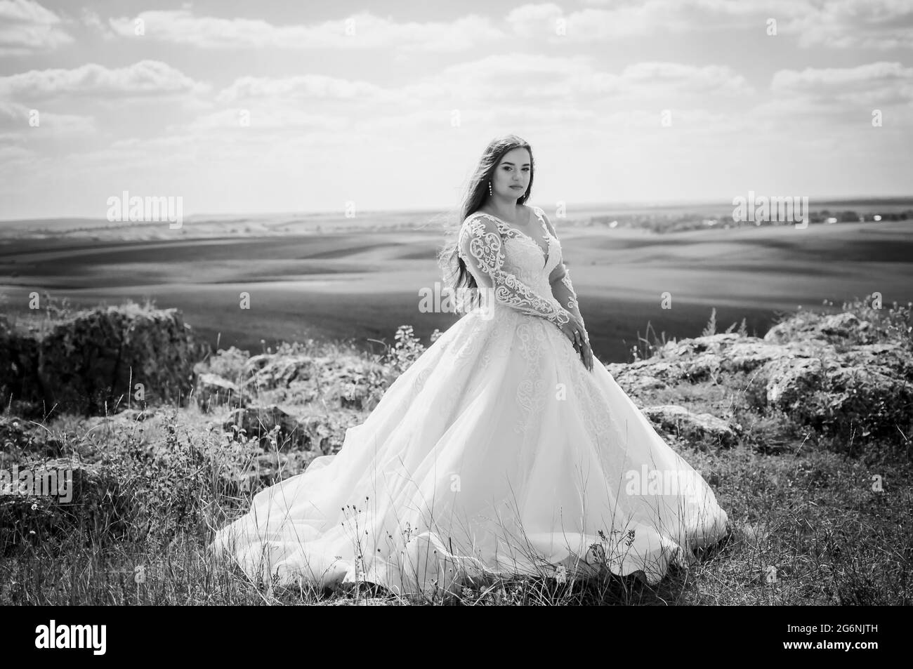 Une fille dans une robe de mariage blanche se tient sur la toile de