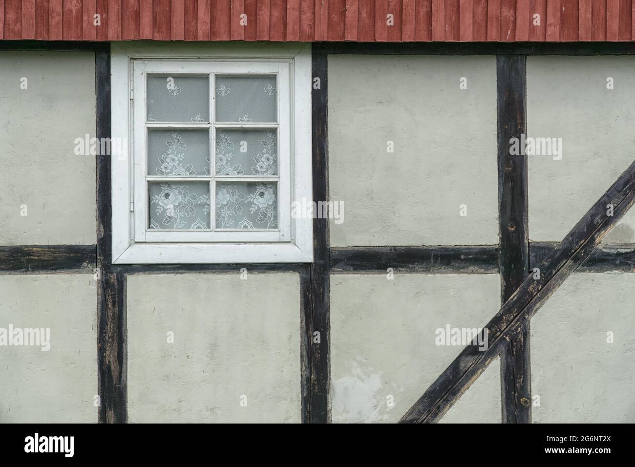 Mur en bois avec fenêtre et toit rouge. Banque D'Images