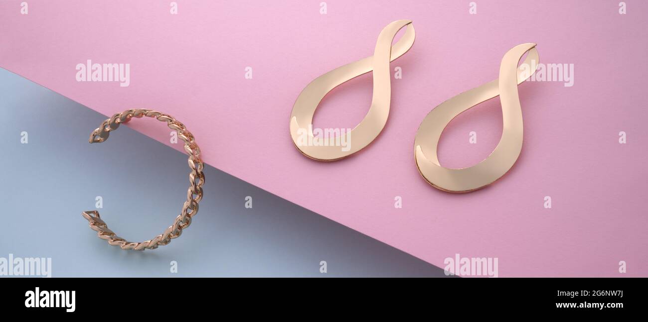 Paire de boucles d'oreilles et bracelet doré en forme de chaîne, rose et bleu Banque D'Images