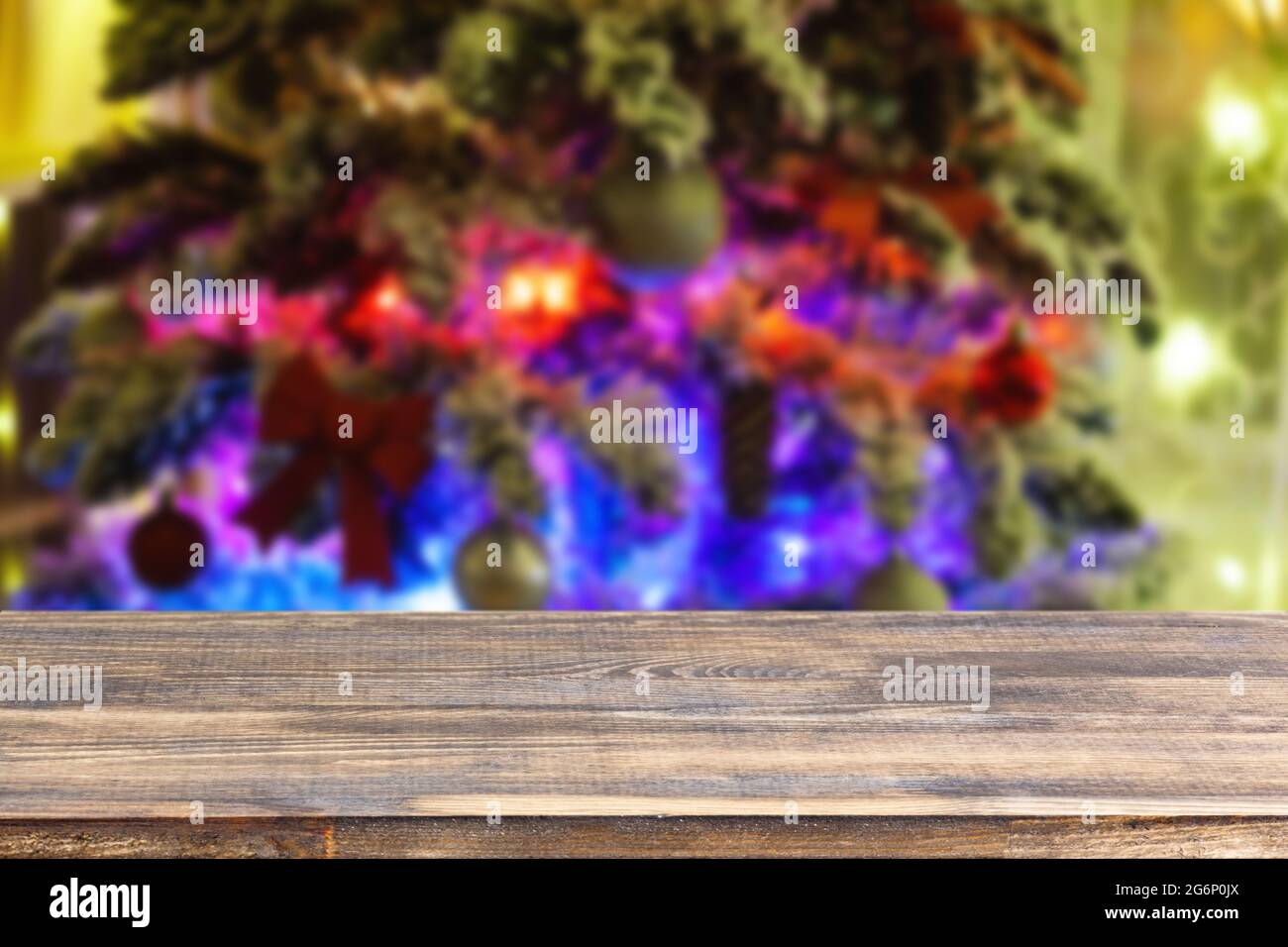 dessus de table en bois sur un arbre de noël flou avec arrière-plan guirlande Banque D'Images