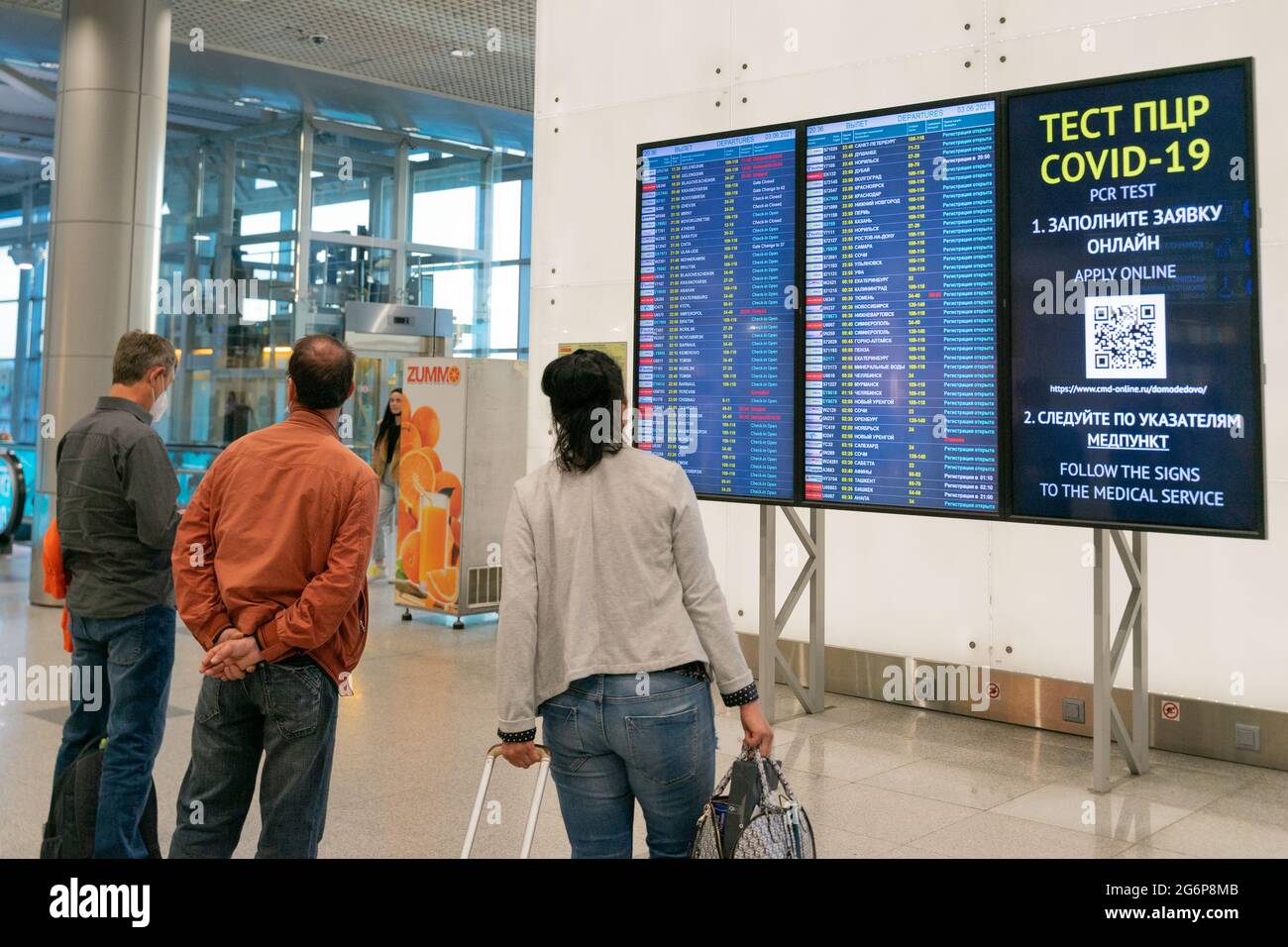 Les passagers devant l'exposition avec des vols et des informations sur les tests pcr Covid dans le terminal de l'aéroport Domodedovo, DME, Moscou. Russie Banque D'Images