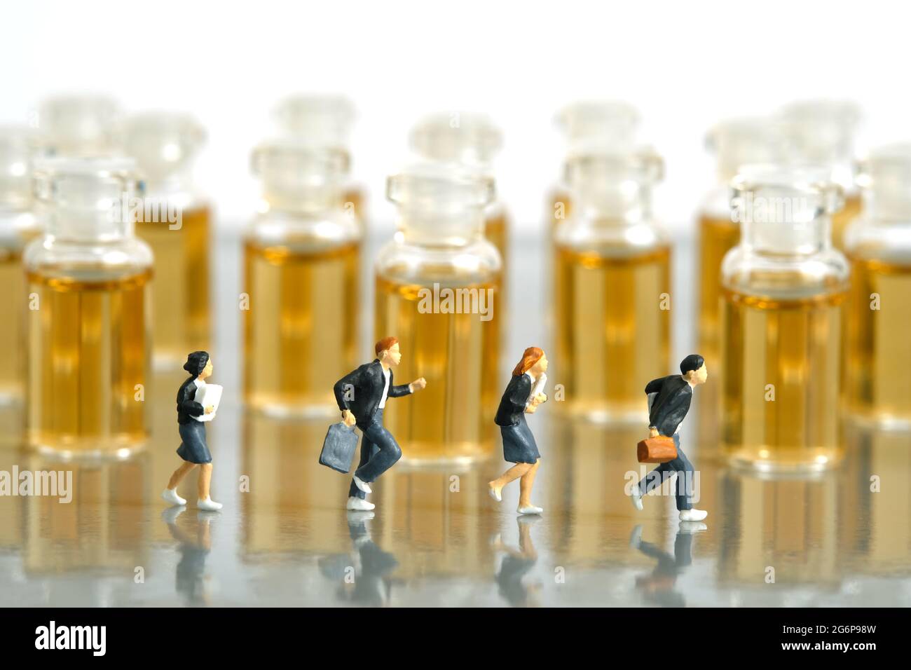 Photographie miniature de personnage de jouet de personnes. Concept de vaccination des adolescents. Un groupe d'élèves du secondaire qui se trouvent devant une bouteille de vaccin en ampoule. JE Banque D'Images