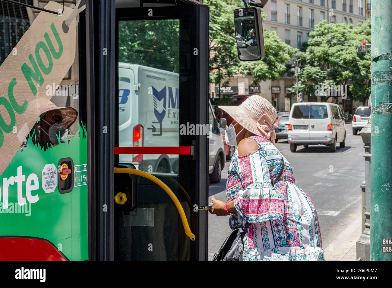 Valence, Espagne. 06e juillet 2021. Une femme portant un masque de visage se met sur un bus hybride à un arrêt de bus. La Société de transport municipal (Empresa Municipal de Transports, EMT) de Valence a réduit l'âge moyen de sa flotte, de 13 ans en 2015 à 7.3 ans, ceci est dû à l'incorporation des 164 derniers nouveaux bus hybrides. Crédit : SOPA Images Limited/Alamy Live News Banque D'Images
