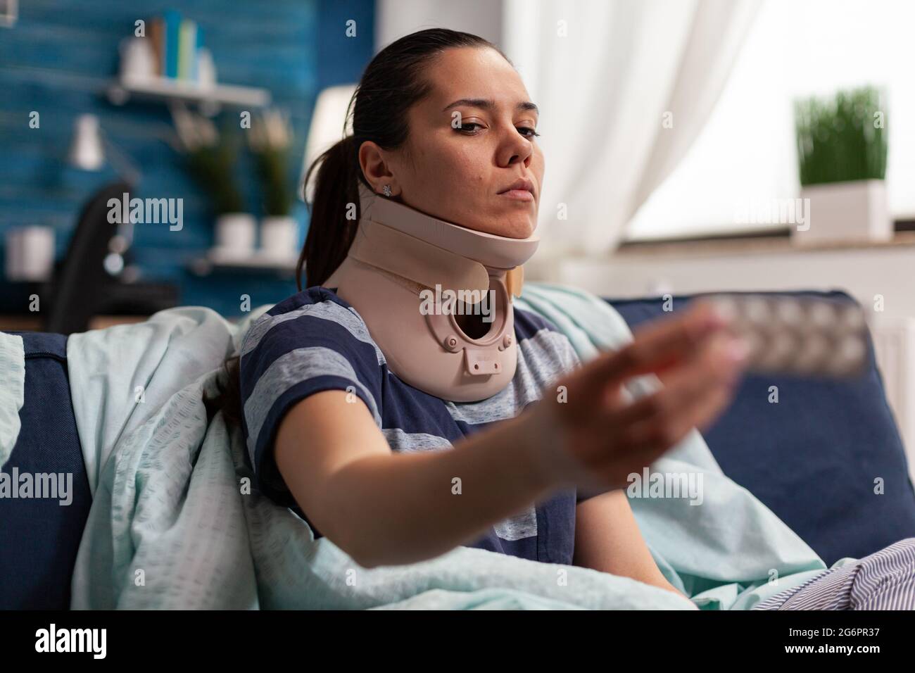 Femme atteinte de maladie et col de mousse cervicale sur le canapé prenant un traitement médical pour les douleurs au dos et au cou. Adulte caucasien présentant une contracture musculaire après une blessure physique dans un accident Banque D'Images