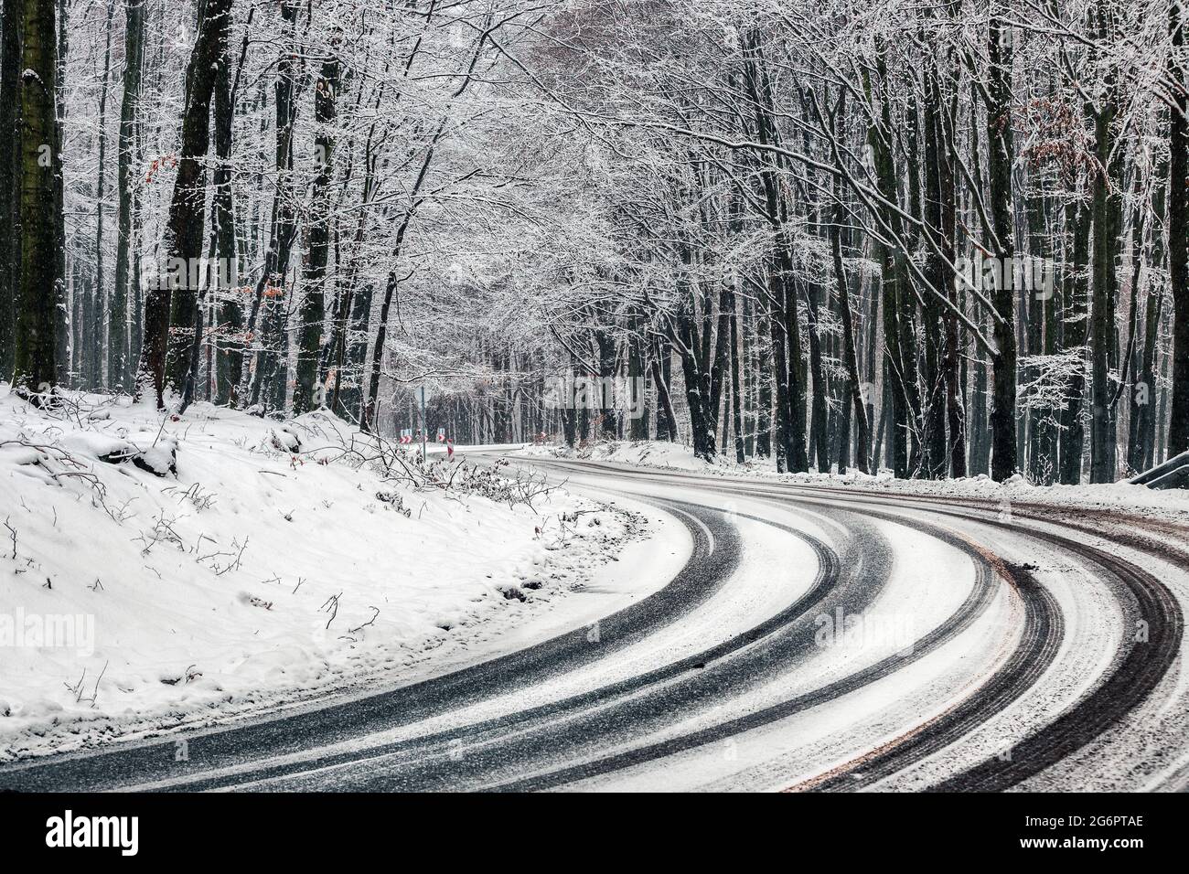 Kekesteto, Hongrie - Winding route d'hiver aux montagnes de Matra près de Kekesteto. Route asphaltée courbée avec des arbres enneigés dans la forêt pendant un hiver froid Banque D'Images