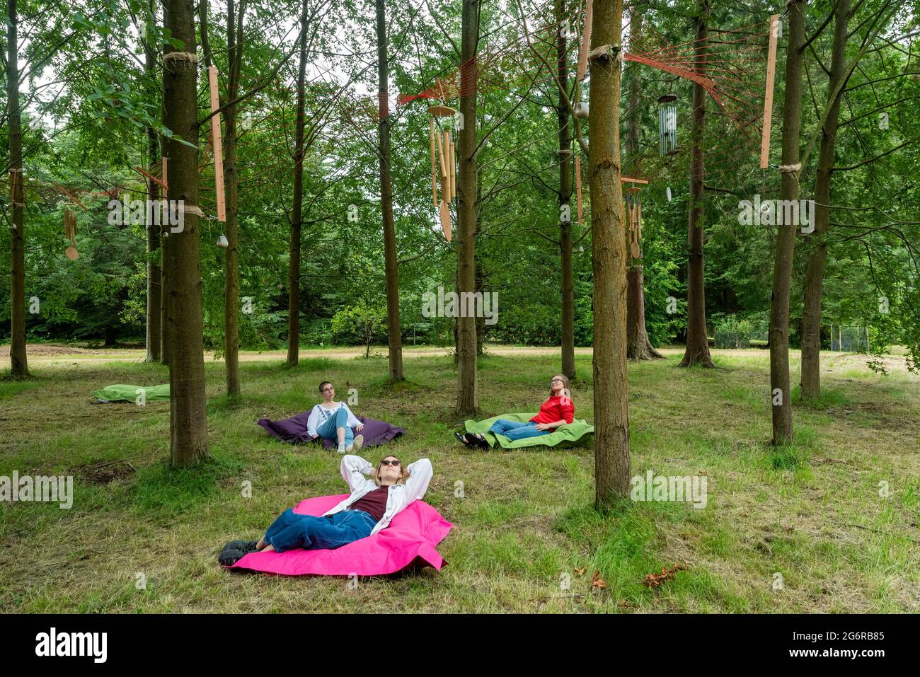 Ardenly, Royaume-Uni. 8 juin 2021. Les membres du personnel écoutent 'Sound Wave' de Plunge Creations, une musique suspendue avec des instruments déclenchés par le vent. Aperçu de Summer of Sound où six installations sonores à grande échelle prennent le contrôle de Wakehurst, le jardin botanique sauvage de Kew à Sussex. Les artistes ont créé des installations offrant des moments de pause et de se sentir connecté à la nature par une symphonie de sons créés ou inspirés par le monde naturel. L'été du son se déroule du 9 juillet au 12 septembre 2021. Credit: Stephen Chung / Alamy Live News Banque D'Images