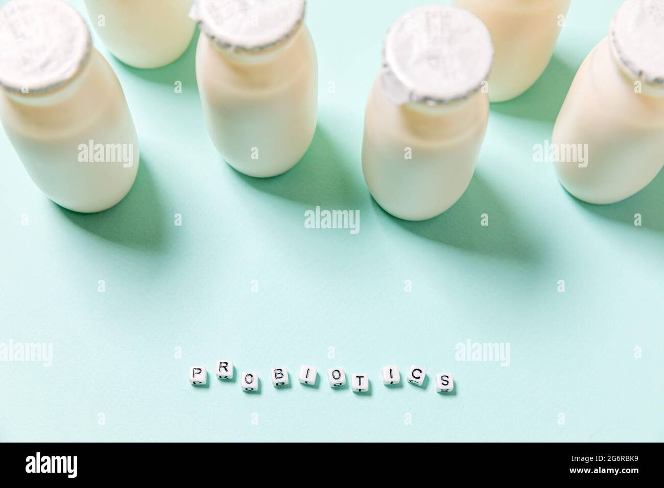 Petits flacons avec probiotiques et prébiotiques boisson laitière sur fond bleu. Production avec des additifs biologiquement actifs. Fermentation et alimentation Banque D'Images