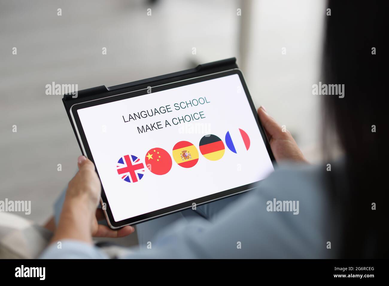 Une femme tient une tablette et choisit une langue étrangère pour étudier Banque D'Images