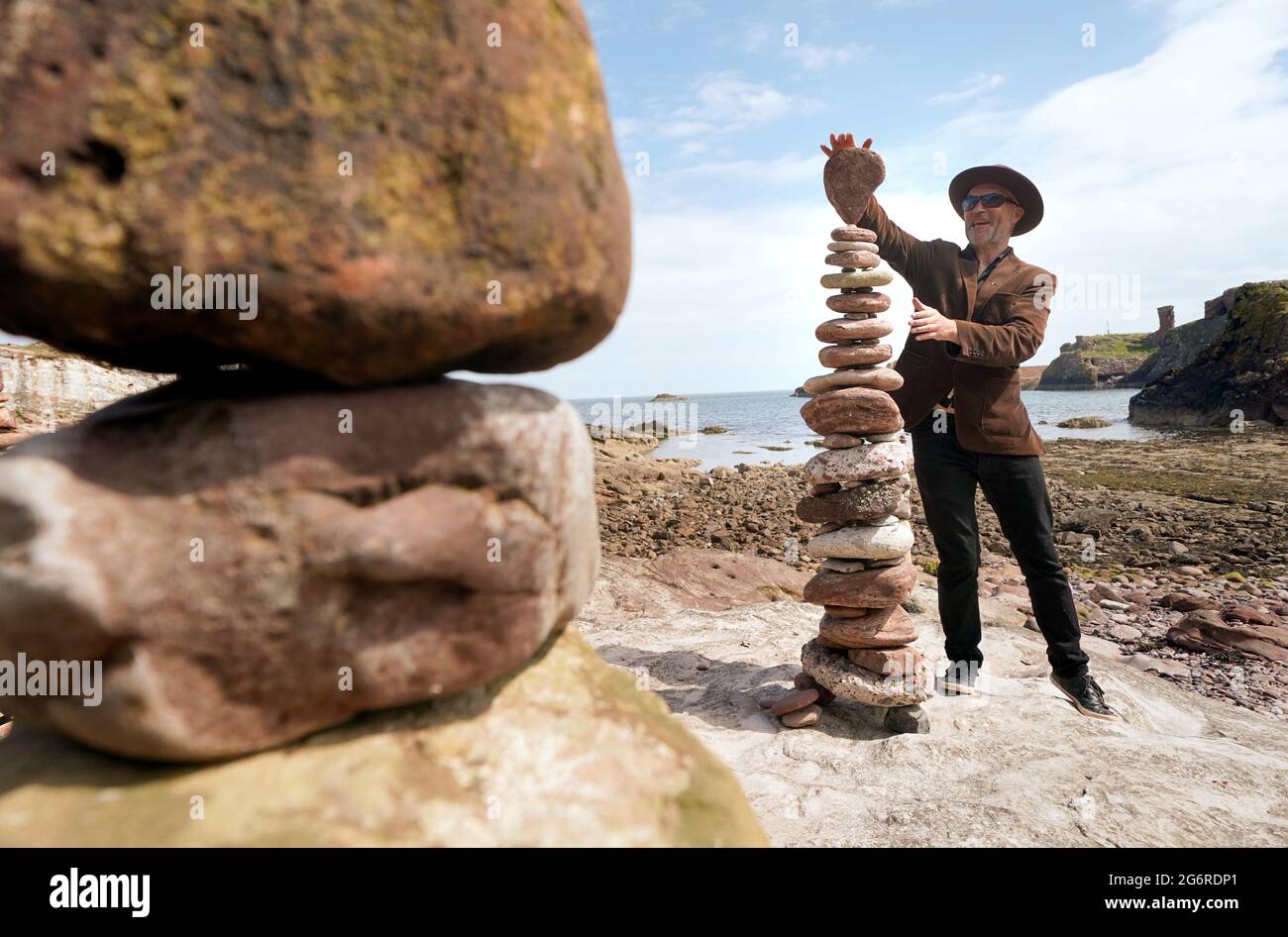 L'artiste James Craig page empile des pierres avec ses créations de sculptures en pierre sur la plage Eye Cave à Dunbar, Lothian est, devant les championnats européens de superposition de pierres. Les amateurs, les familles et les papillotes de pierre professionnels participeront à divers défis le samedi et le dimanche. Date de la photo: Jeudi 8 juillet 2021. Banque D'Images