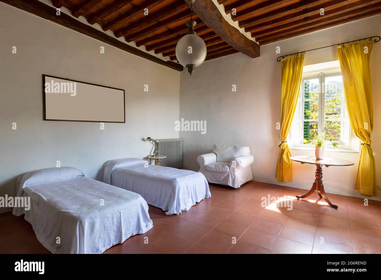 Intérieur d'une chambre avec deux lits simples. Ambiance Spartan et rien de luxueux. Il n'y a personne à l'intérieur et les sols sont rouges et magnifiques. Banque D'Images