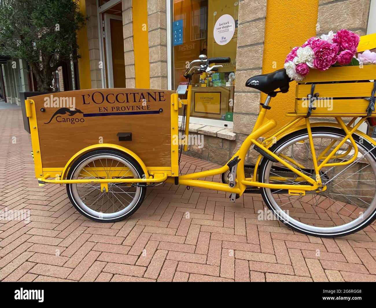 Roermond, pays-Bas - 1er juillet. 2021: Vue sur le vélo de transport jaune devant l'entrée du magasin avec le logo de l'occitane en provence c Banque D'Images