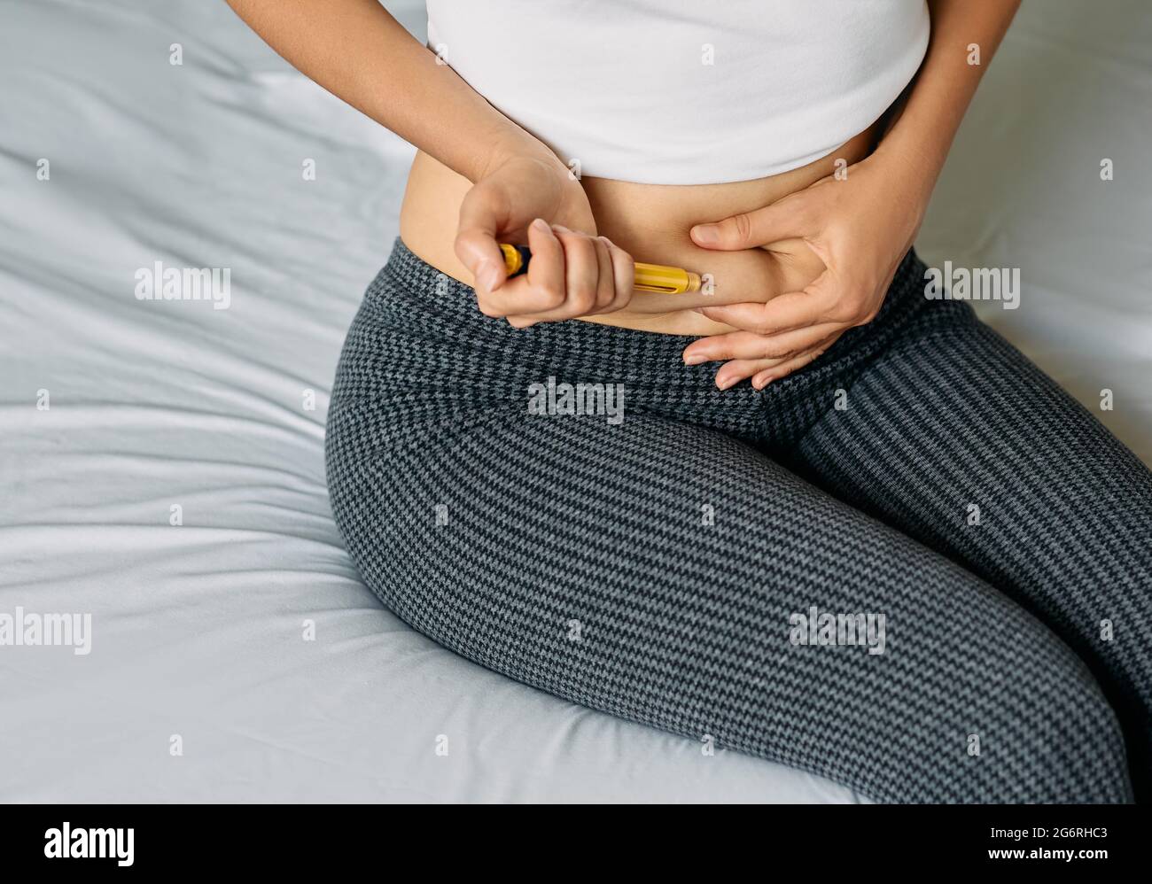 La femme injecte une hormone dans son abdomen pour stimuler la croissance folliculaire. Préparation d'une femme pour la procédure FIV Banque D'Images