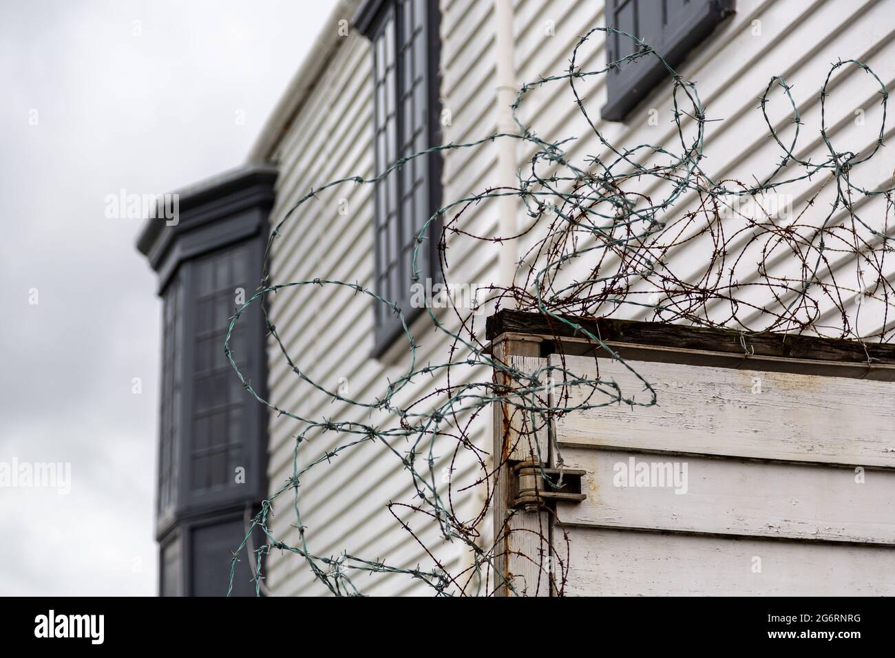 Vieux fil barbelé rouillé sur une clôture à une maison comme mesure de sécurité Banque D'Images