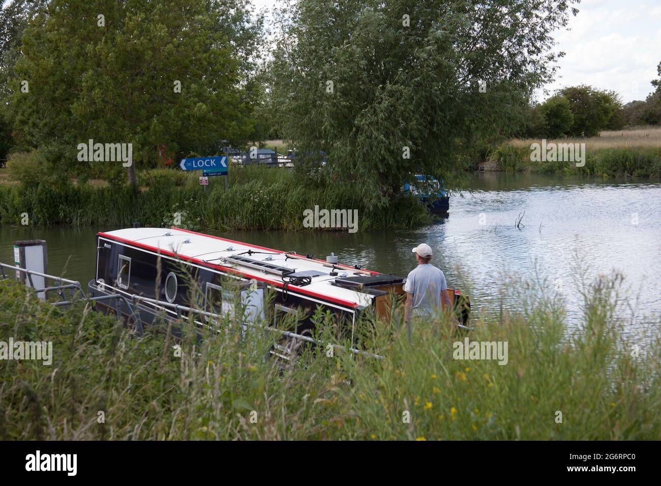 Un homme prend sa barge sur la Tamise à Farmoor, dans l'Oxfordshire, au Royaume-Uni Banque D'Images