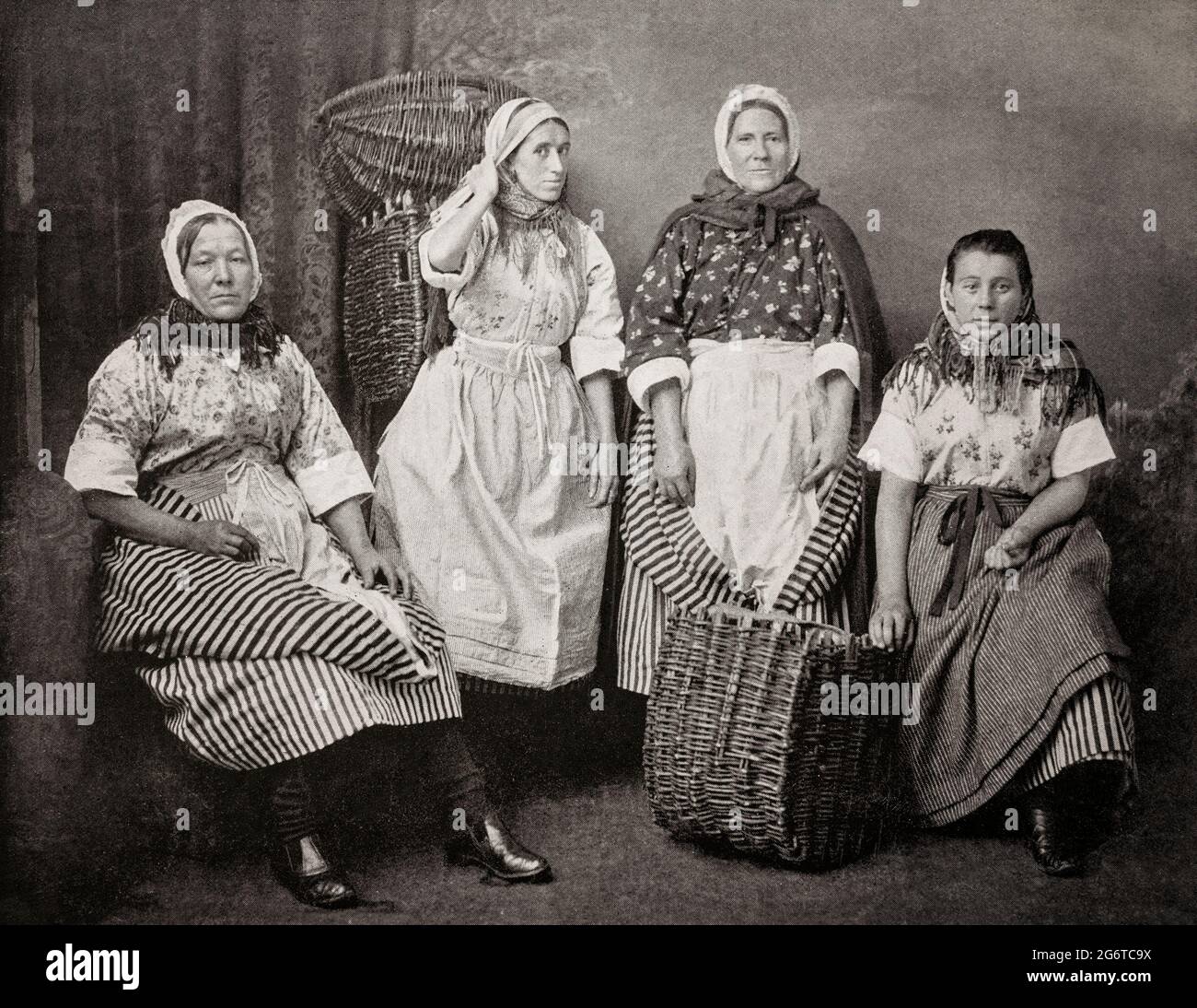 Un portrait de Fishwives de Newhaven, un port de pêche situé à la périphérie d'Édimbourg, en Écosse, datant de la fin du XIXe siècle. Ils avaient l’habitude de fouler Édimbourg avec leurs crèches sur le dos pour vendre du poisson de porte en porte, en appelant ‘Caller Herring’ («Fresh Herrings») ou ‘Caller ou’ (huîtres), faisant écho dans les rues de la vieille ville. Ils étaient célèbres dans tout le pays pour leurs tenues traditionnelles aux couleurs vives, leur stature robuste et leurs visages séduits, leur panache et leurs petites phrases. Ils étaient renommés pour leurs langues acérées, qui ont donné naissance à l'expression écossaise « une langue comme une femme de poisson » Banque D'Images