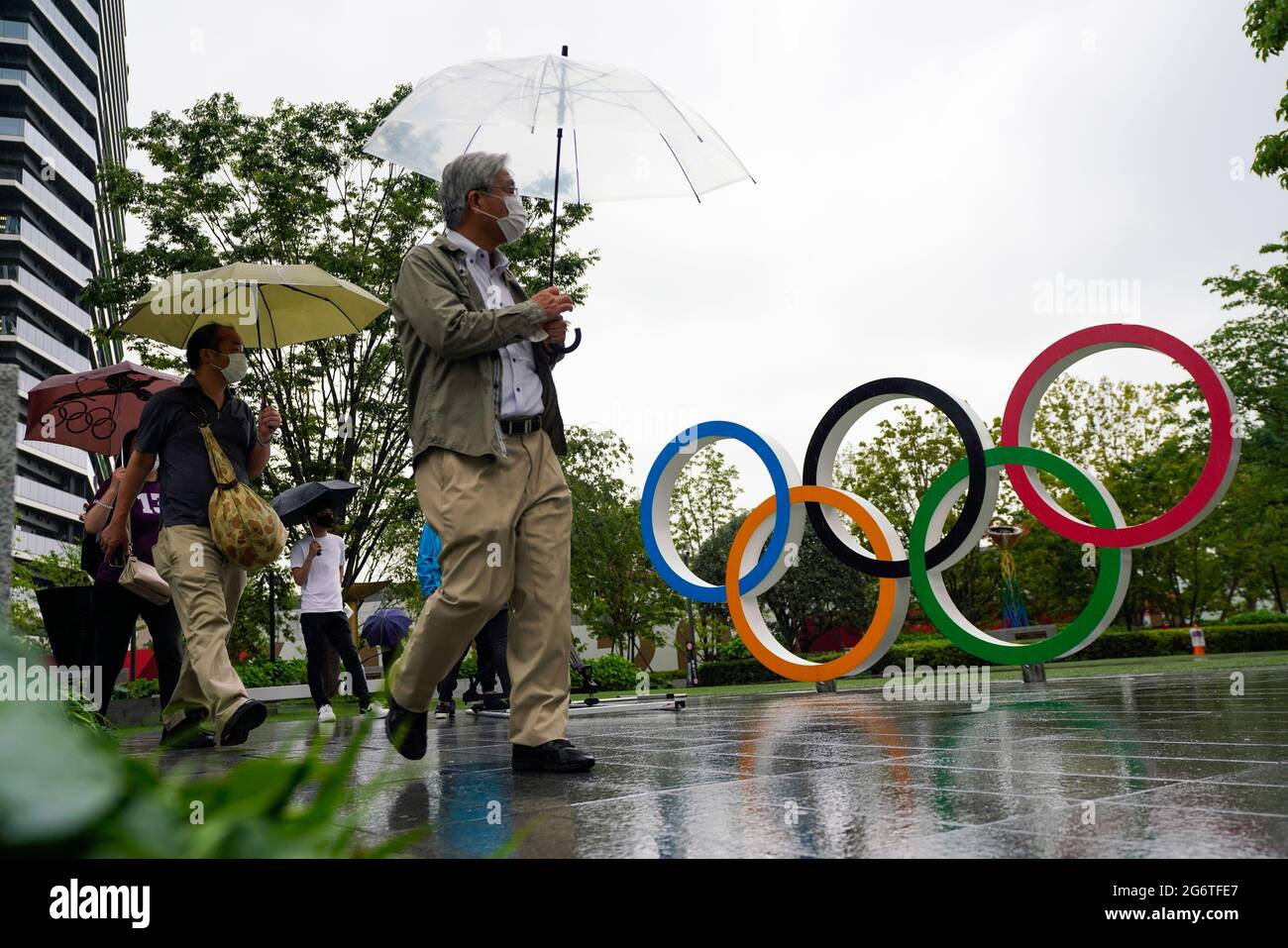 (210708) -- TOKYO, le 8 juillet 2021 (Xinhua) -- les gens marchent devant les anneaux olympiques près du nouveau stade national de Tokyo, au Japon, le 8 juillet 2021. Le gouvernement japonais a décidé jeudi de placer la capitale Tokyo sous le quatrième état d'urgence sur la COVID-19, couvrant la durée des Jeux Olympiques, dans un effort pour enrayer une récente vague d'infections. (Photo de Christopher Jue/Xinhua) Banque D'Images