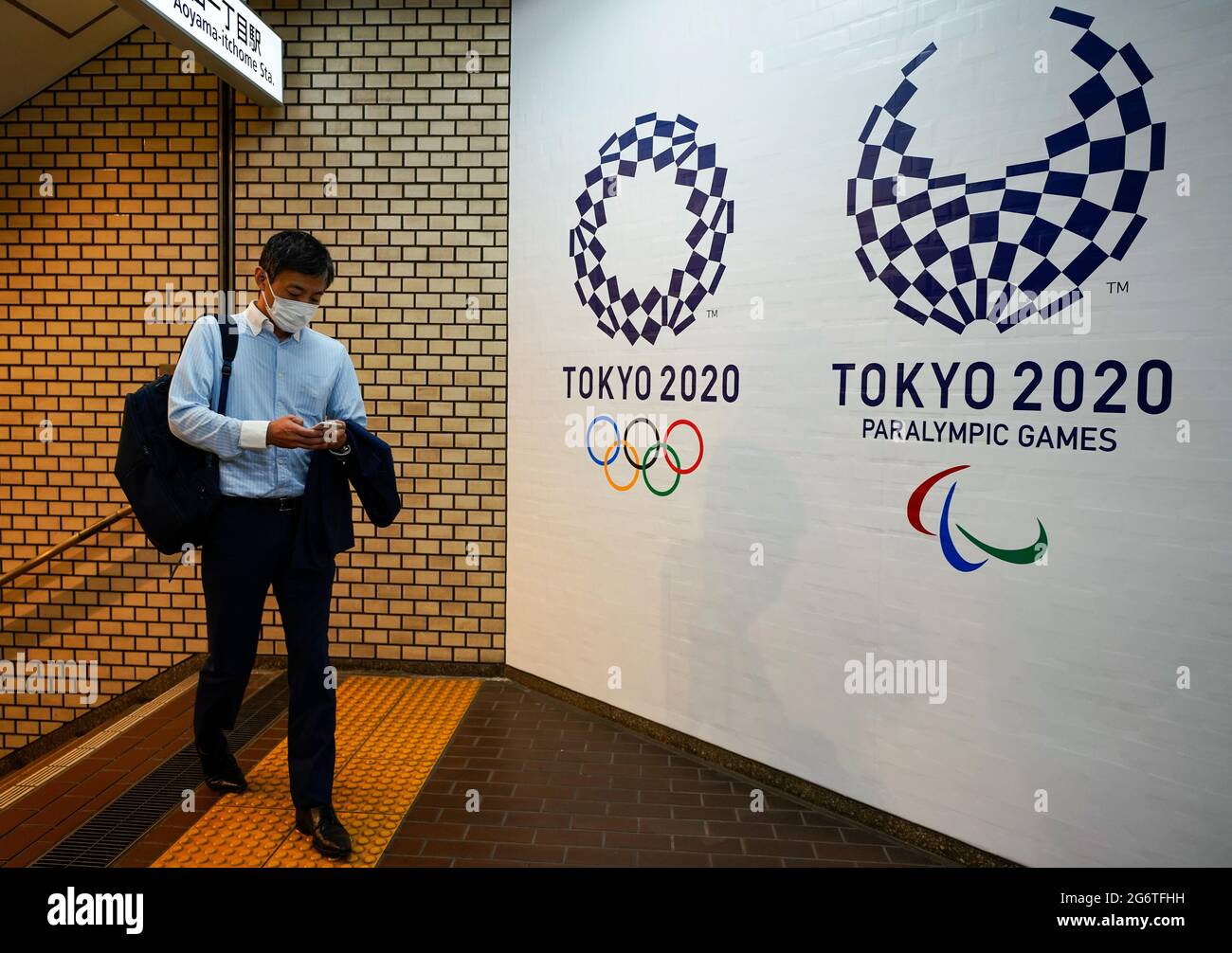 (210708) -- TOKYO, le 8 juillet 2021 (Xinhua) -- UN homme sort d'une gare et affiche les logos des Jeux paralympiques de Tokyo 2020 et de Tokyo 2020 à Tokyo, au Japon, le 8 juillet 2021. Le gouvernement japonais a décidé jeudi de placer la capitale Tokyo sous le quatrième état d'urgence sur la COVID-19, couvrant la durée des Jeux Olympiques, dans un effort pour enrayer une récente vague d'infections. (Photo de Christopher Jue/Xinhua) Banque D'Images