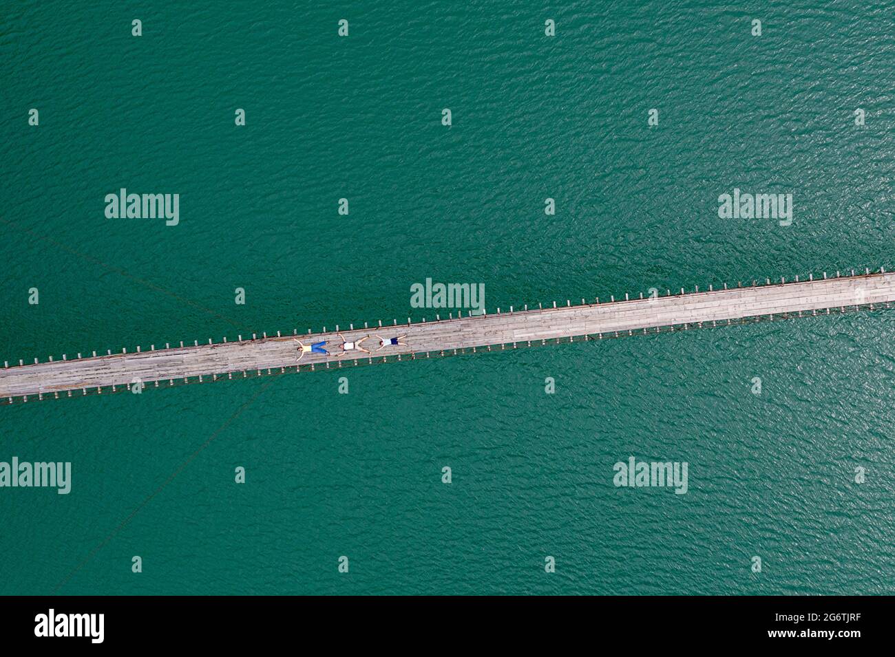 Vue aérienne de la famille sur un pont suspendu ou suspendu en bois au-dessus de la belle rivière émeraude, prise par drone, Albanie Banque D'Images