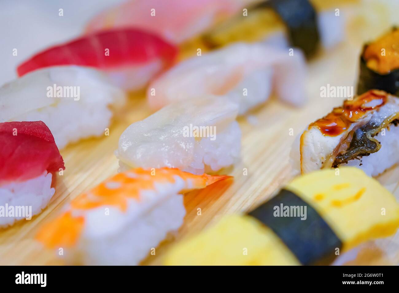 Gros plan sur divers morceaux de riz pressé à la main nigirizushi ou sushi aux fruits de mer, y compris des congridae anago japonais, des œufs grillés au tamagoyaki, un shrim ebi Banque D'Images