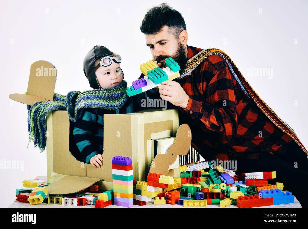 Concept de famille et d'enfance. Son fils et son père jouent avec des blocs de plastique colorés. Le père et l'enfant passent du temps ensemble. Banque D'Images
