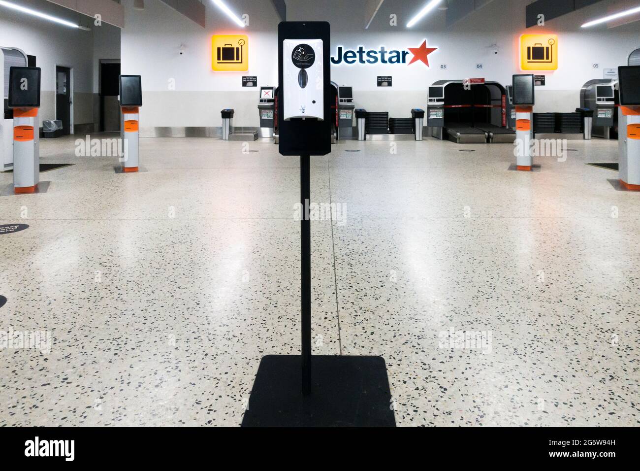 Terminal aérien Jetstar déserté à l'aéroport Tullamarine de Melbourne, en Australie pendant le confinement. Désinfectant pour les mains au premier plan. Banque D'Images