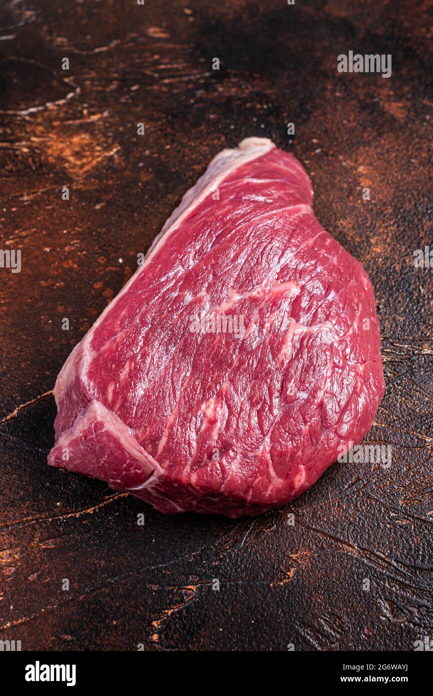 Bœuf cru coupé ou steak de viande de sirloin sur la table de boucher. Arrière-plan sombre. Vue de dessus Banque D'Images