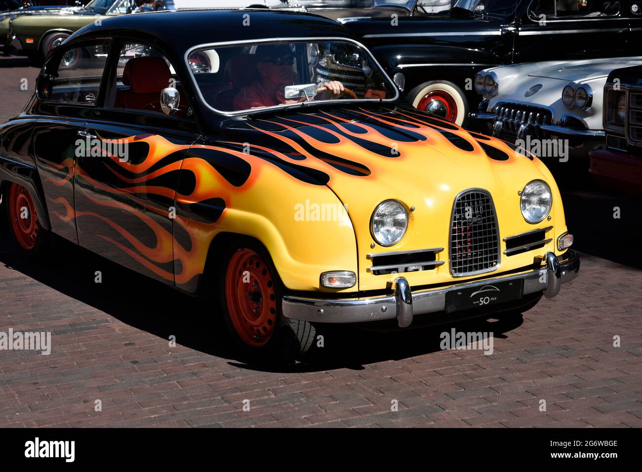 Un homme qui conduit sa Saab 1964 avec des flammes peintes arrive à un spectacle de voitures classiques du 4 juillet à Santa Fe, au Nouveau-Mexique. Banque D'Images