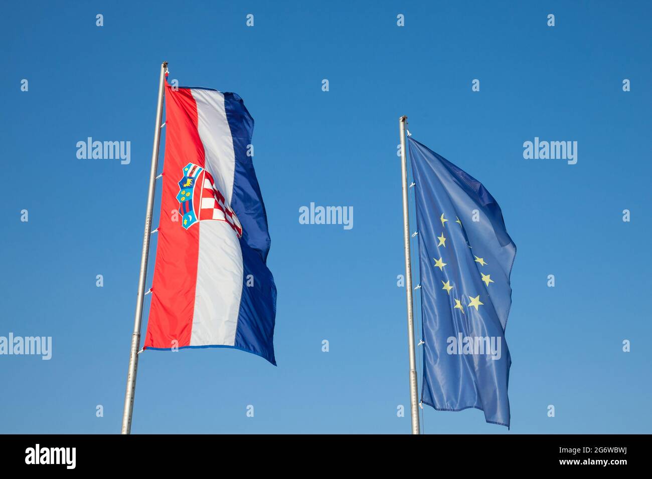 Photo des drapeaux de la Croatie et de l'UE qui se sont enfuis dans l'air derrière un ciel bleu ensoleillé. L'élargissement de l'Union européenne en 2013 a vu la Croatie rejoindre le Banque D'Images