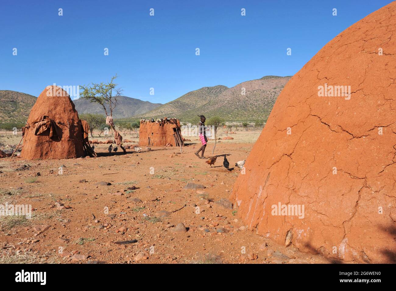 NAMIBIE. LE VILLAGE DE HIMBA, OU KRAAL, EST COMPOSÉ DE QUELQUES HUTTES EN BOIS ET EN ARGILE AVEC UNE FAMILLE DANS CHACUN ET QUELQUES ENDROITS POUR LE BÉTAIL. Banque D'Images