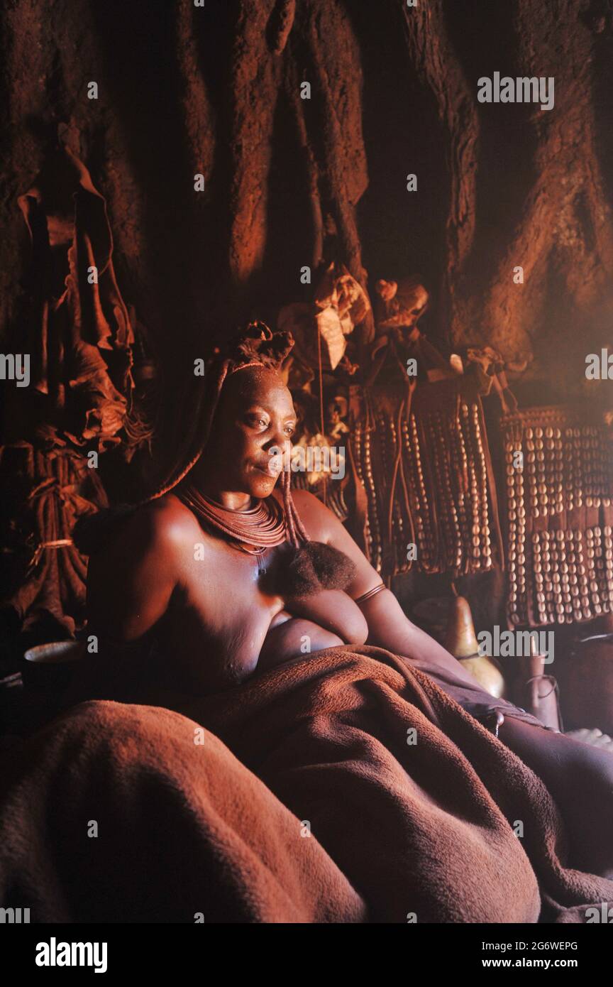 NAMIBIE. FEMME HIMBA AYANT UN PEU DE REPOS DANS SA HUTTE. Banque D'Images