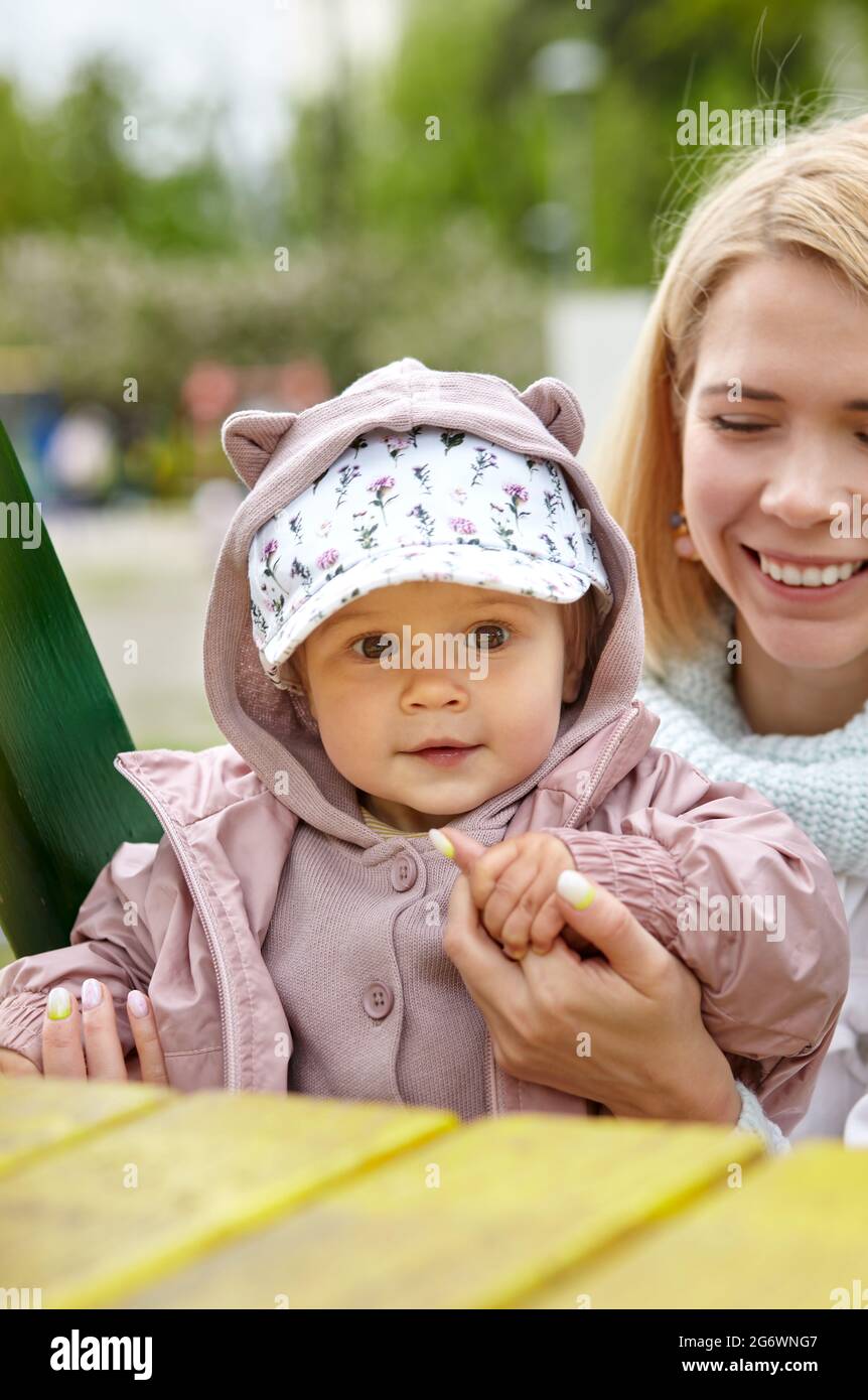 Maman et fille sur l'aire de jeux extérieure. Activité saine pour les enfants. La petite fille et la mère ont un bon moment Banque D'Images