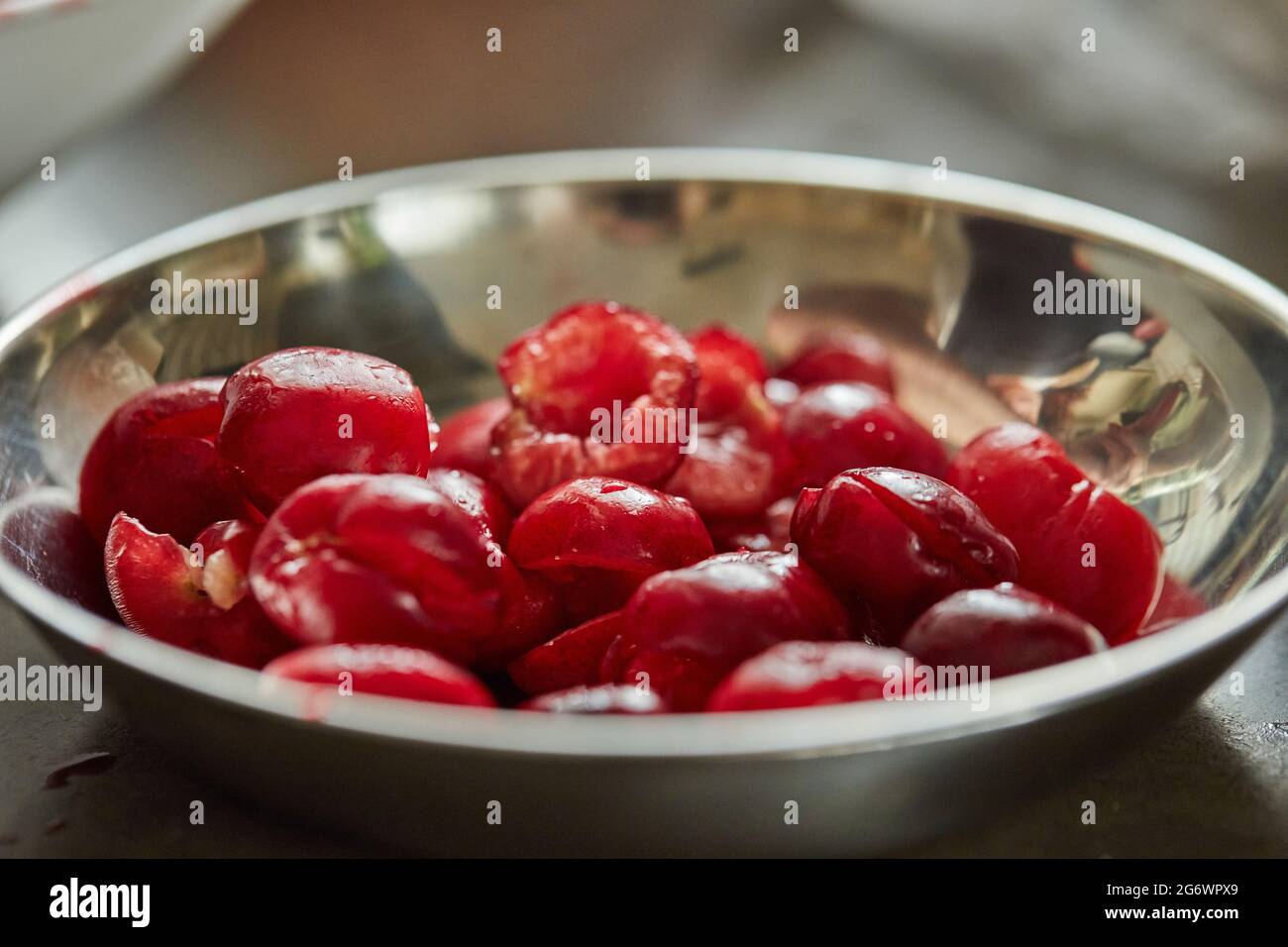 Les cerises dénoyautées sont prêtes dans un bol à tarte. Recette étape par étape Banque D'Images