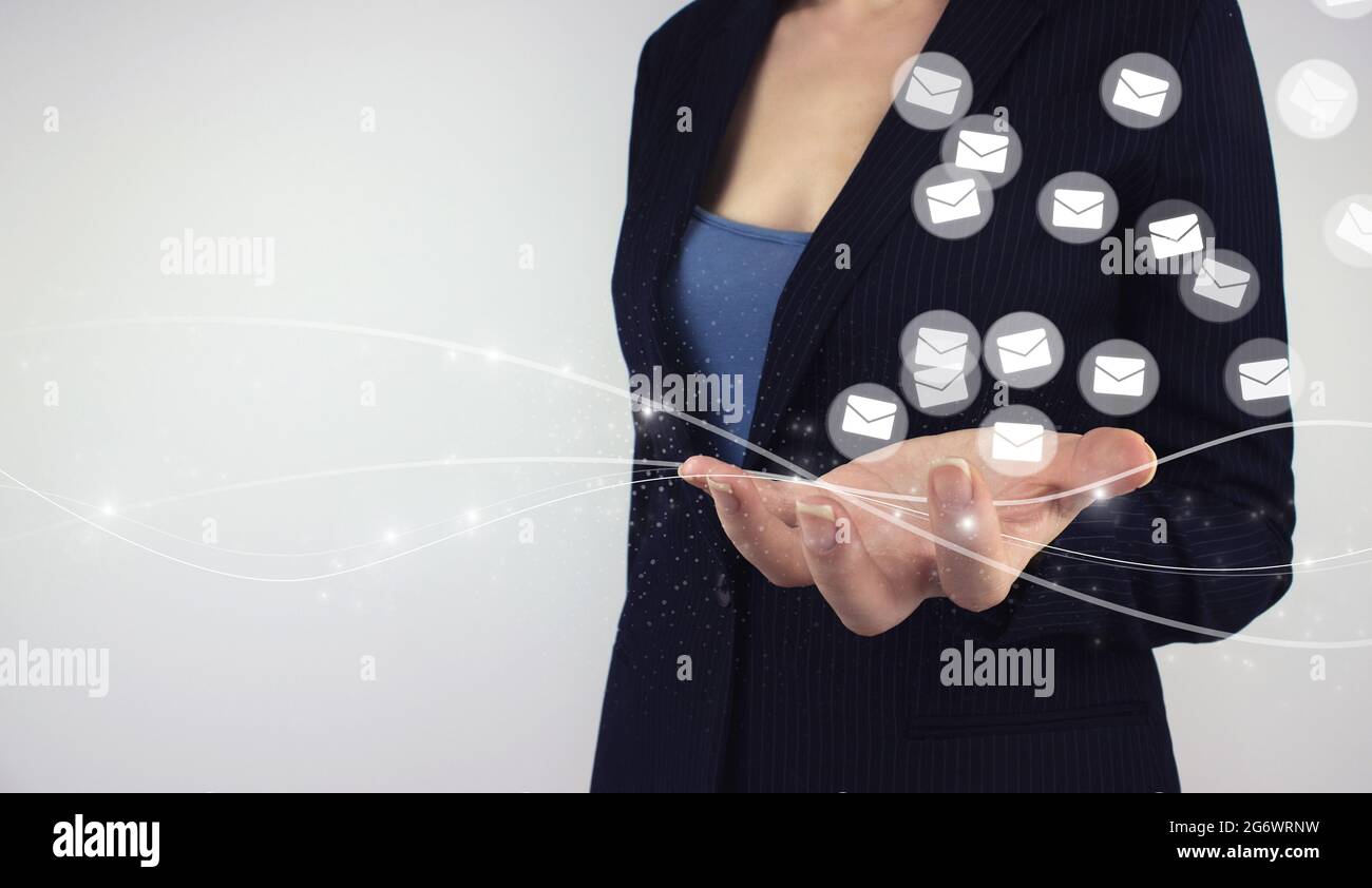concept de marketing par e-mail, nombreux e-mails ou newsletter numérique aux clients. Main tenir la lettre de l'hologramme numérique, icônes d'email sur fond gris Banque D'Images
