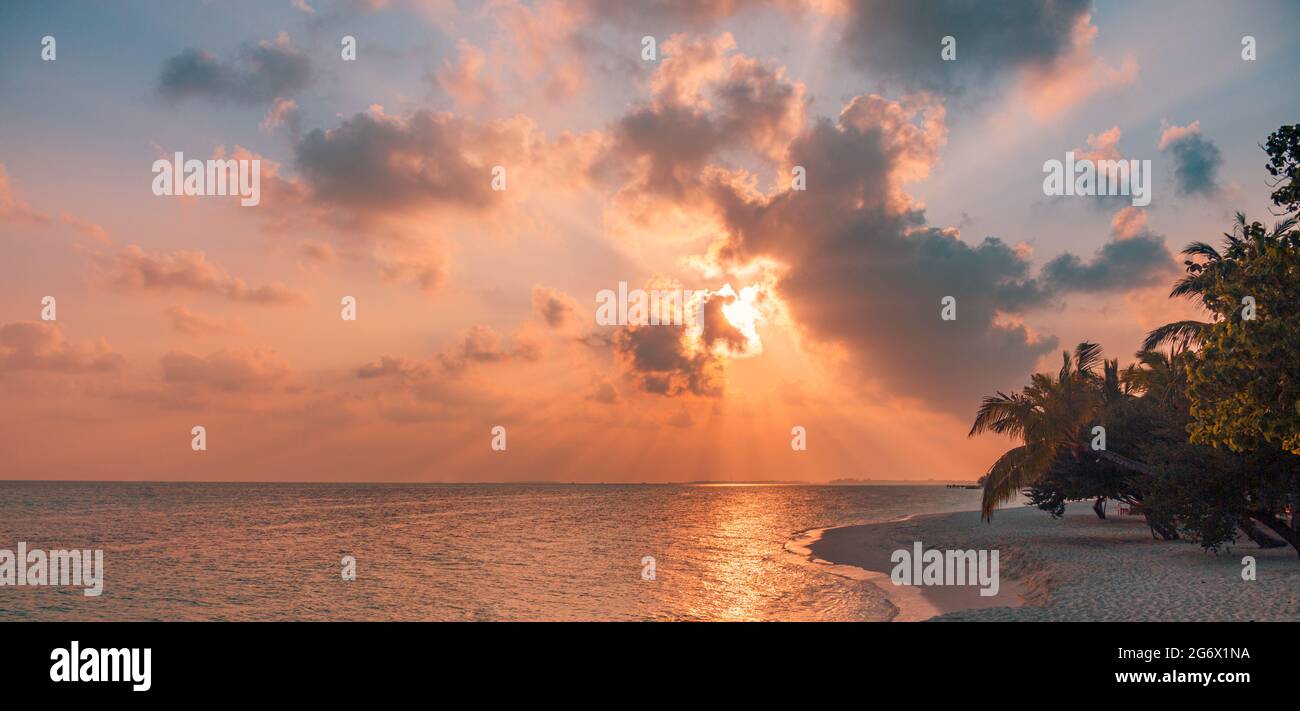 Coucher de soleil sur la plage. Paradis paysage plage. Paradis tropical, sable blanc, plage, palmiers et eau claire sous les rayons du soleil avec un été idyllique Banque D'Images