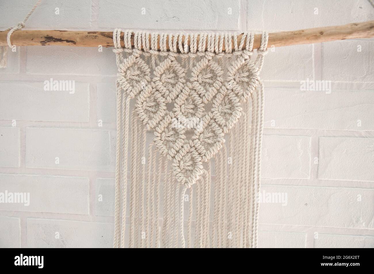 Murale boho en fils de coton de couleur naturelle utilisant la technique du macrame pour la décoration de la maison et du mariage Banque D'Images