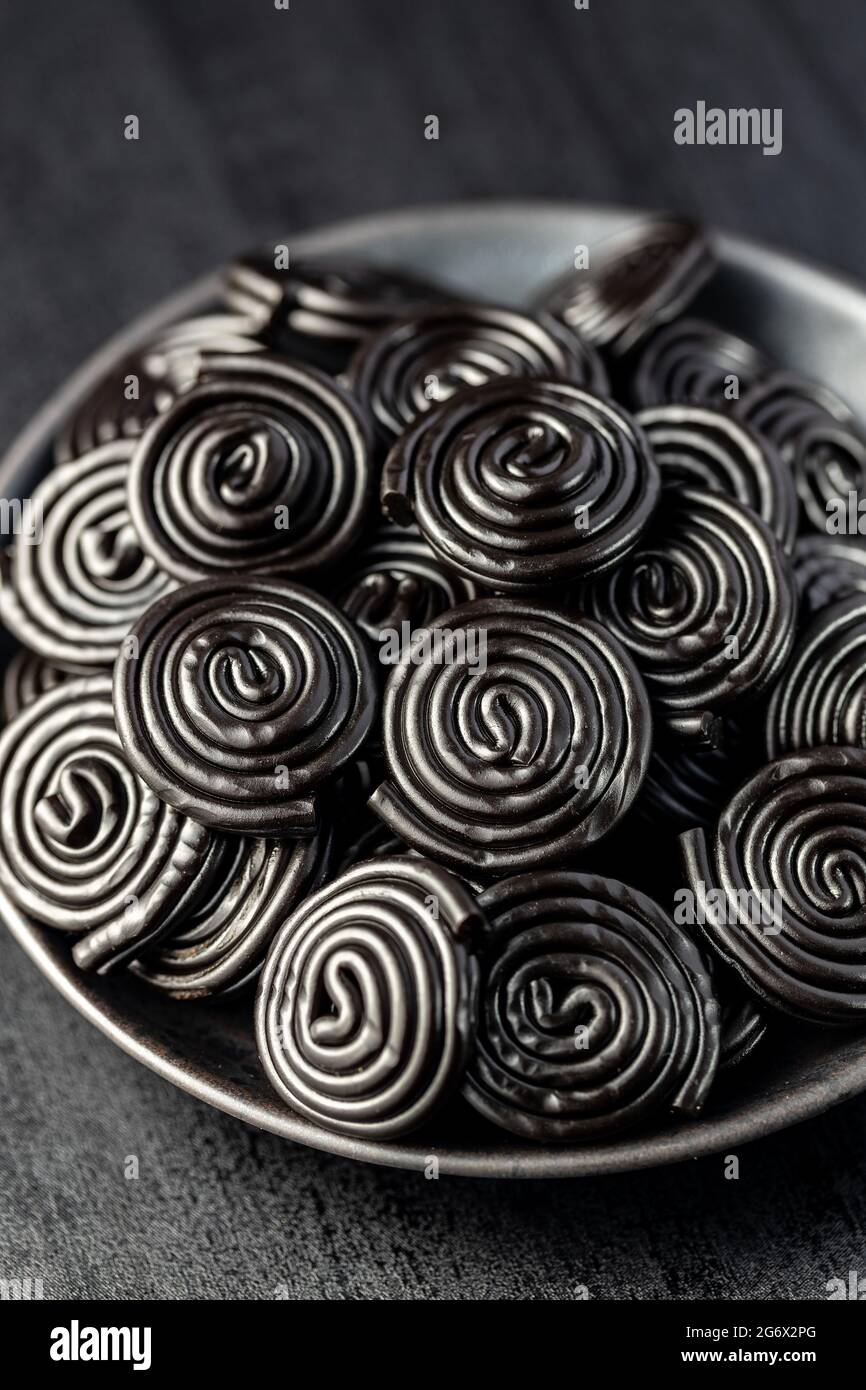 Spirale de friandises de réglisse sur plaque noire. Banque D'Images