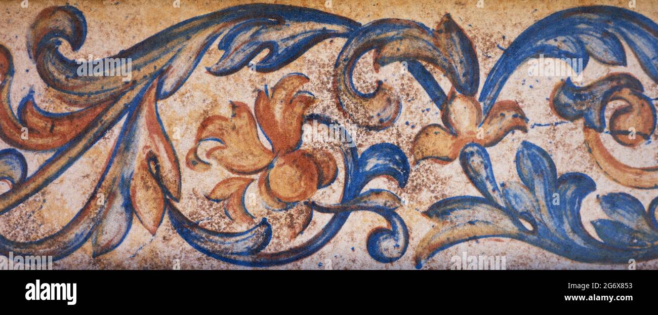 détail d'une bordure peinte sur une tuile avec des fleurs rouges, orange et bleues Banque D'Images