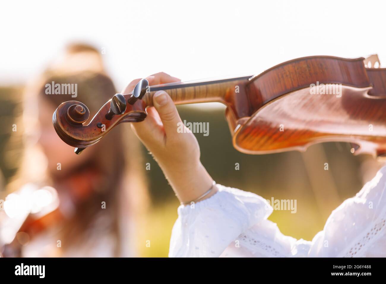 Accent sélectif sur le violon d'une jeune fille jouant à l'extérieur pendant le festival d'été Banque D'Images