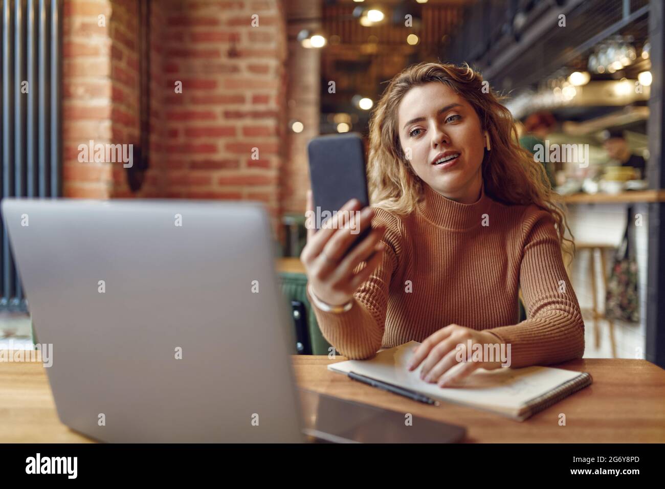 Femme dans un casque avec chat vidéo sur un smartphone Banque D'Images