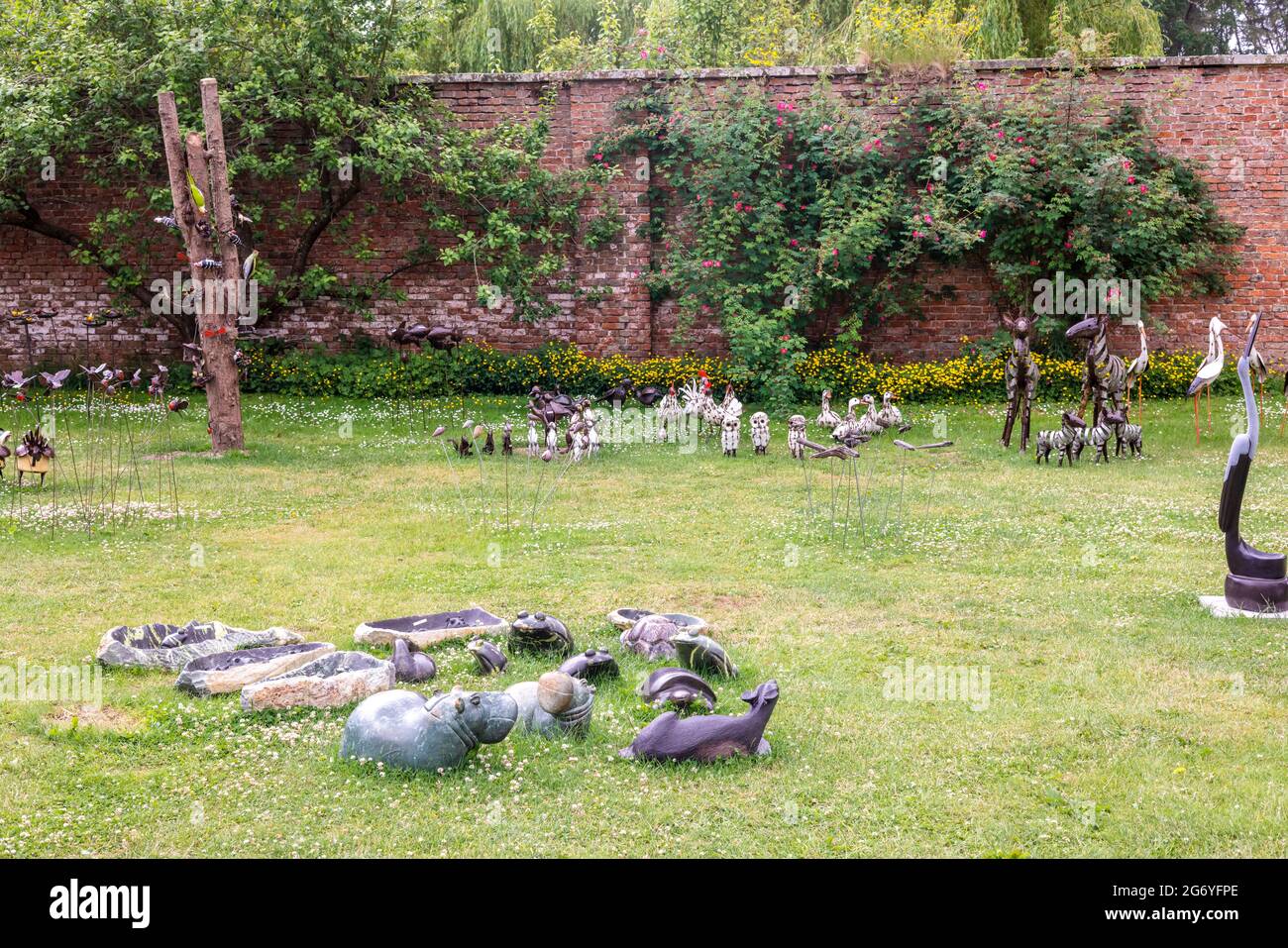 Petits oiseaux et sculptures fantaisistes d'animaux exposés au hasard dans un parc. Banque D'Images