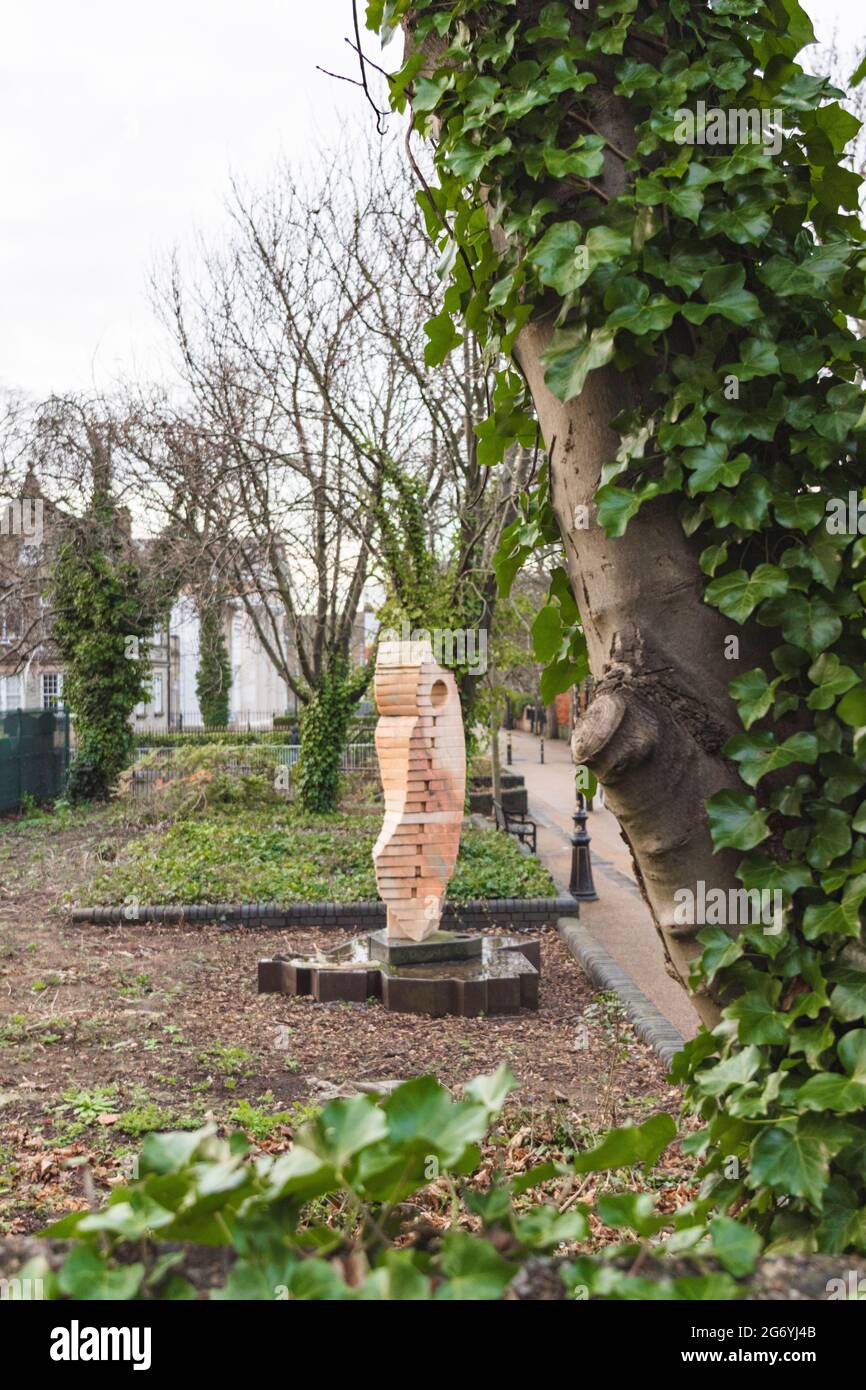 La sculpture de Clothier de John Atkin, de nombreux arbres et haies. Grand arbre à travers la photo avec l'ivy grandissant. Affiche le nouveau musée de la promenade en arrière-plan. Banque D'Images