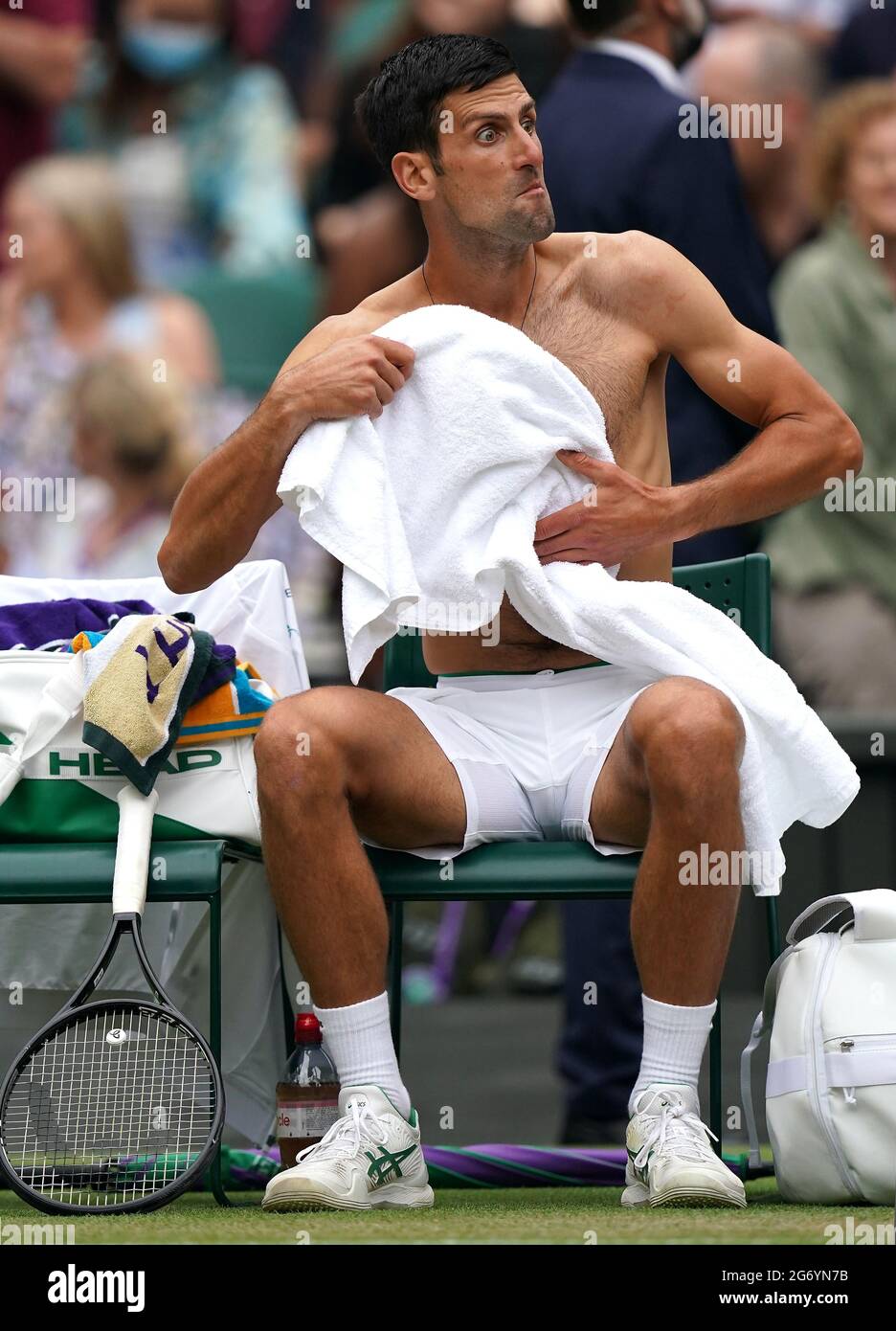 Novak Djokovic change de maillot lors d'une pause en jeu contre Denis Shapovalov lors du match de demi-finale sur le court central le 11 jour de Wimbledon au All England Lawn tennis and Croquet Club, Wimbledon. Date de la photo : vendredi 9 juillet 2021. Banque D'Images
