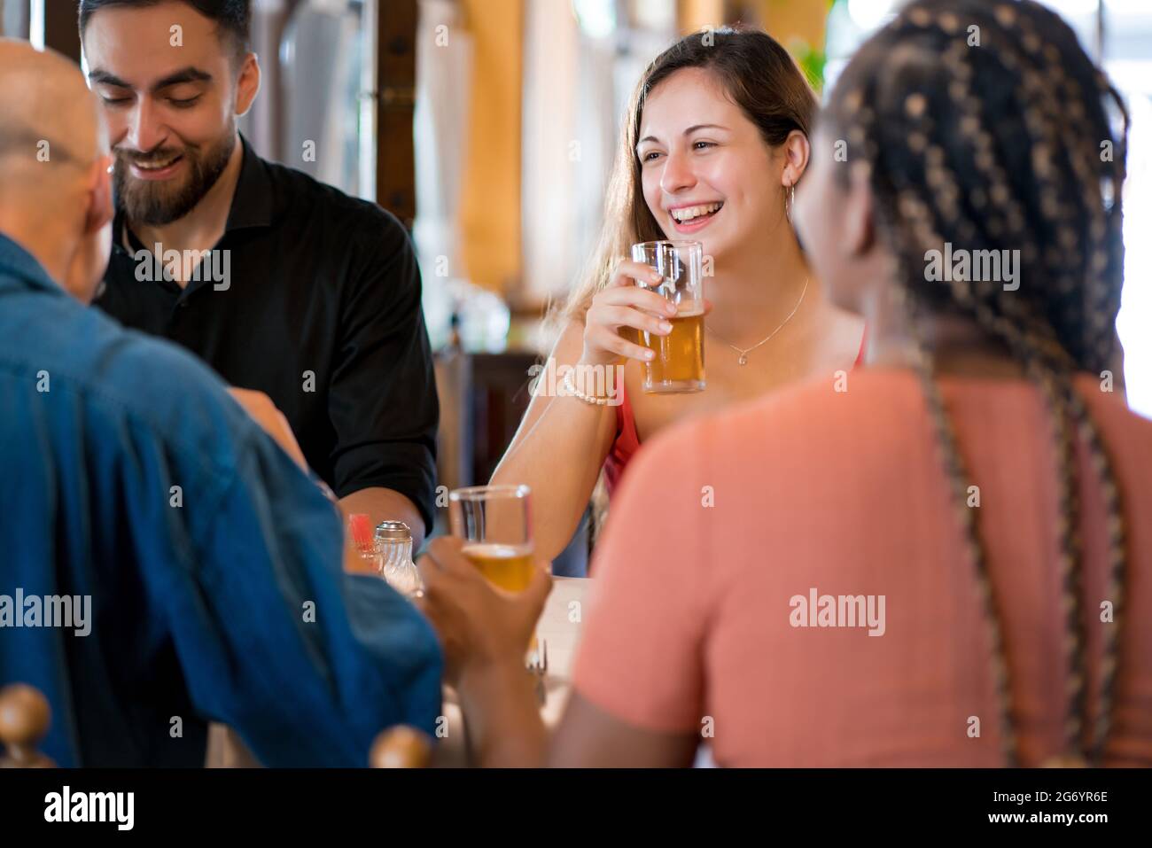 Groupe d'amis qui apprécient de boire de la bière ensemble dans un bar. Banque D'Images