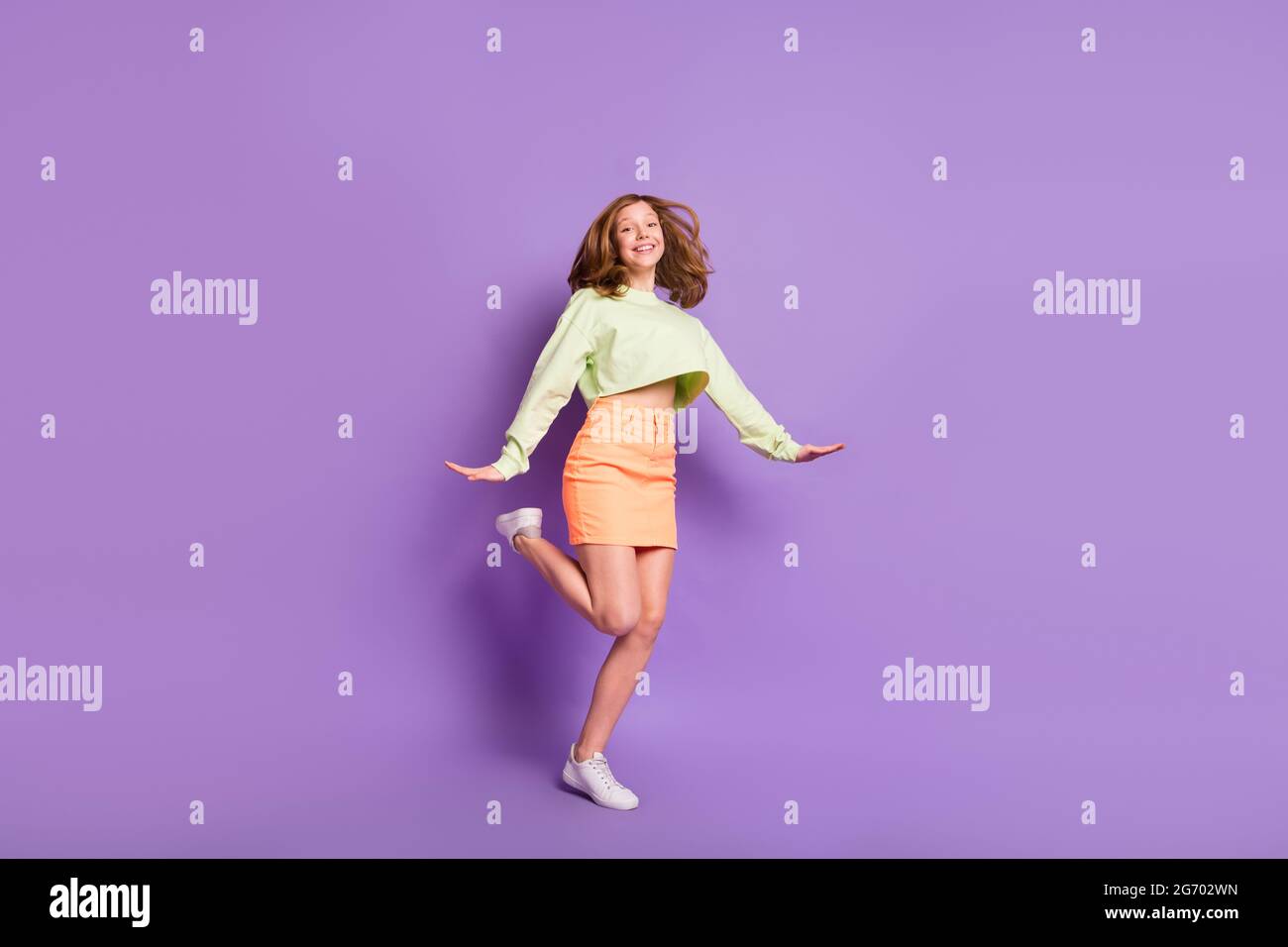 Pleine longueur profil côté photo de jeune fille gaie heureux positif sourire porter décontracté tenue isolée sur fond violet couleur Banque D'Images