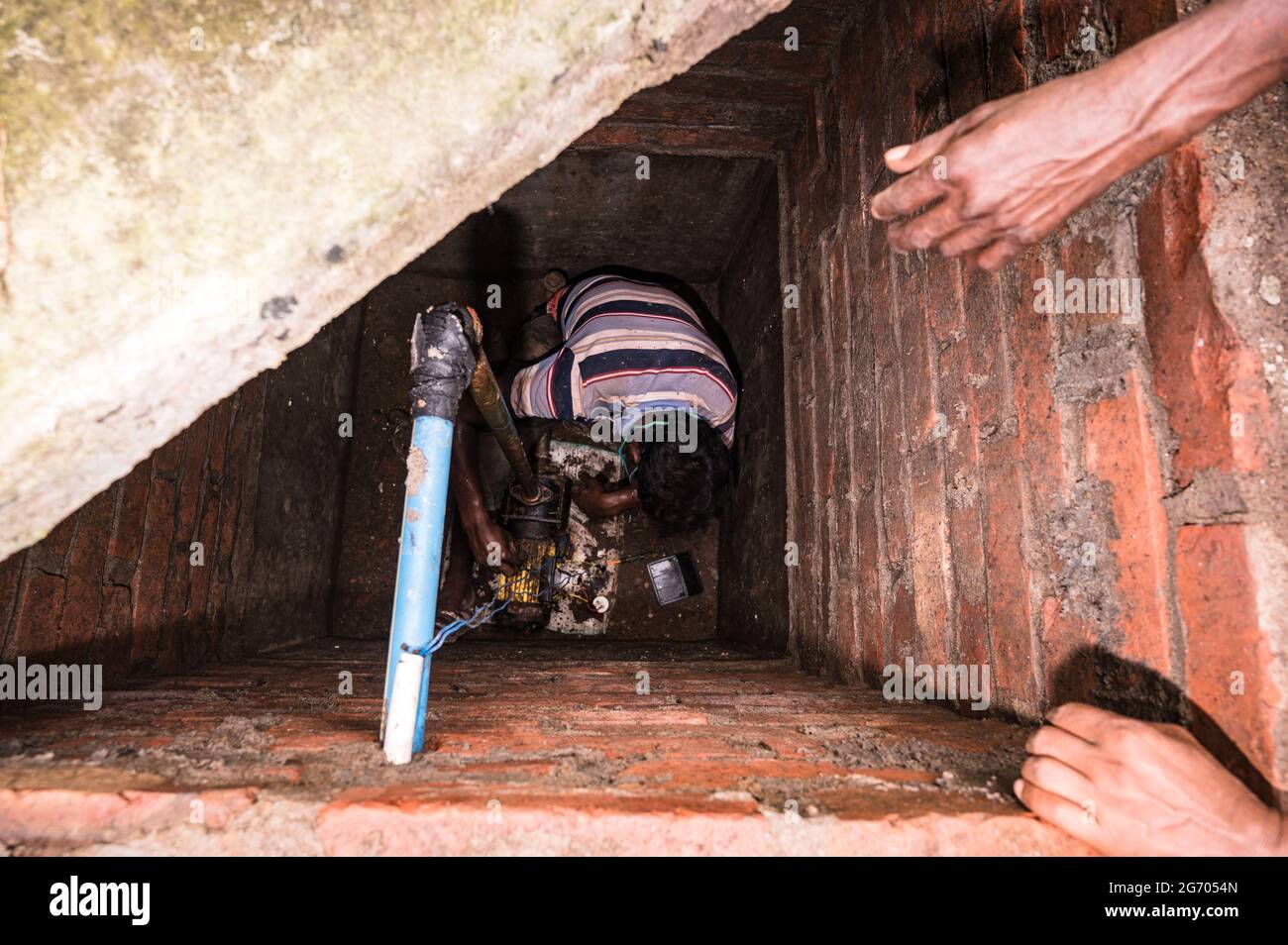 Le gouvernement du Bengale occidental a déclaré que les travaux de construction pourraient reprendre si les entreprises vaccinaient leurs employés et fournissaient un lieu de séjour aux travailleurs. Les mécaniciens réparent une pompe conforme aux règles en vigueur à Tehatta, Bengale-Occidental; Inde. Banque D'Images