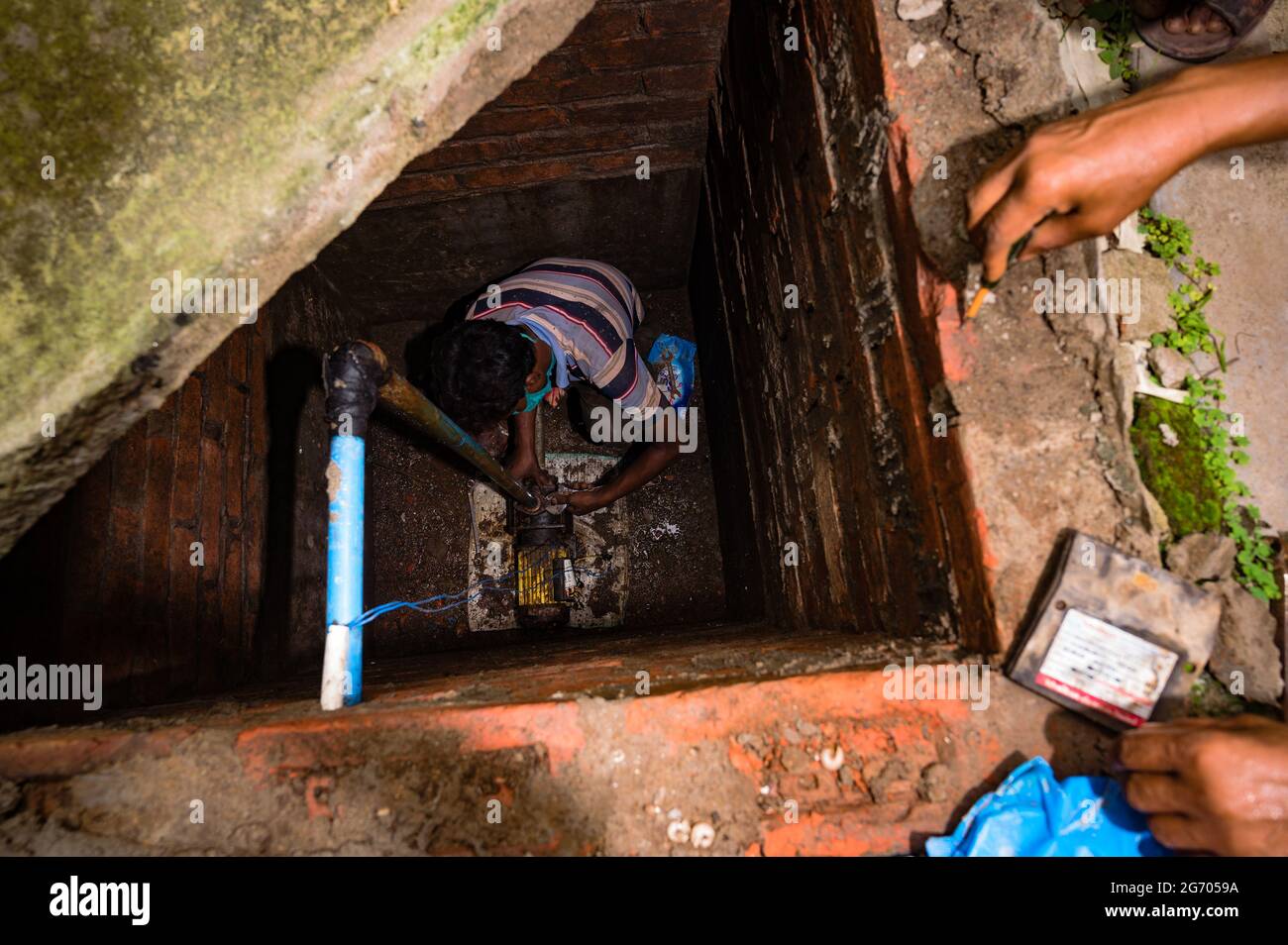 Le gouvernement du Bengale occidental a déclaré que les travaux de construction pourraient reprendre si les entreprises vaccinaient leurs employés et fournissaient un lieu de séjour aux travailleurs. Les mécaniciens réparent une pompe conforme aux règles en vigueur à Tehatta, Bengale-Occidental; Inde. Banque D'Images